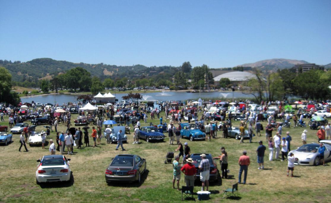 View of the concourse area of Lagoon Park with a car show and people walking around looking at the classic cars.