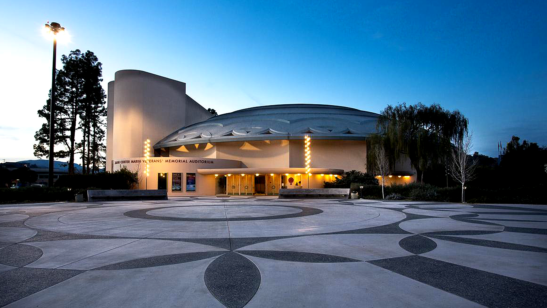 An exterior view of the Marin Veterans' Memorial Auditorium as the sun sets in the background. 