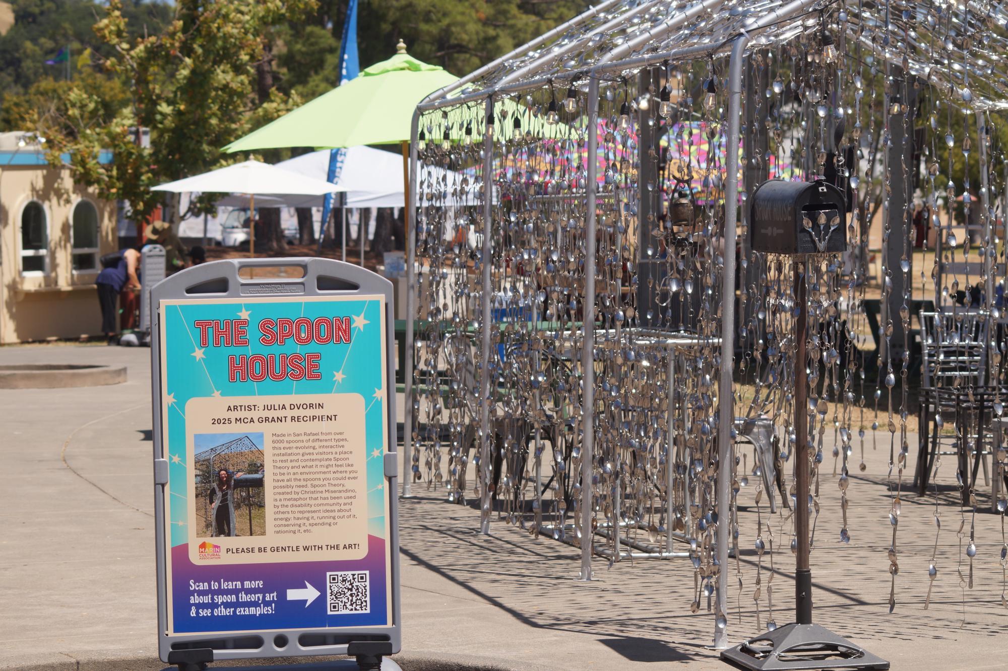 A house made of hanging spoons with a sign that says "The Spoon House."