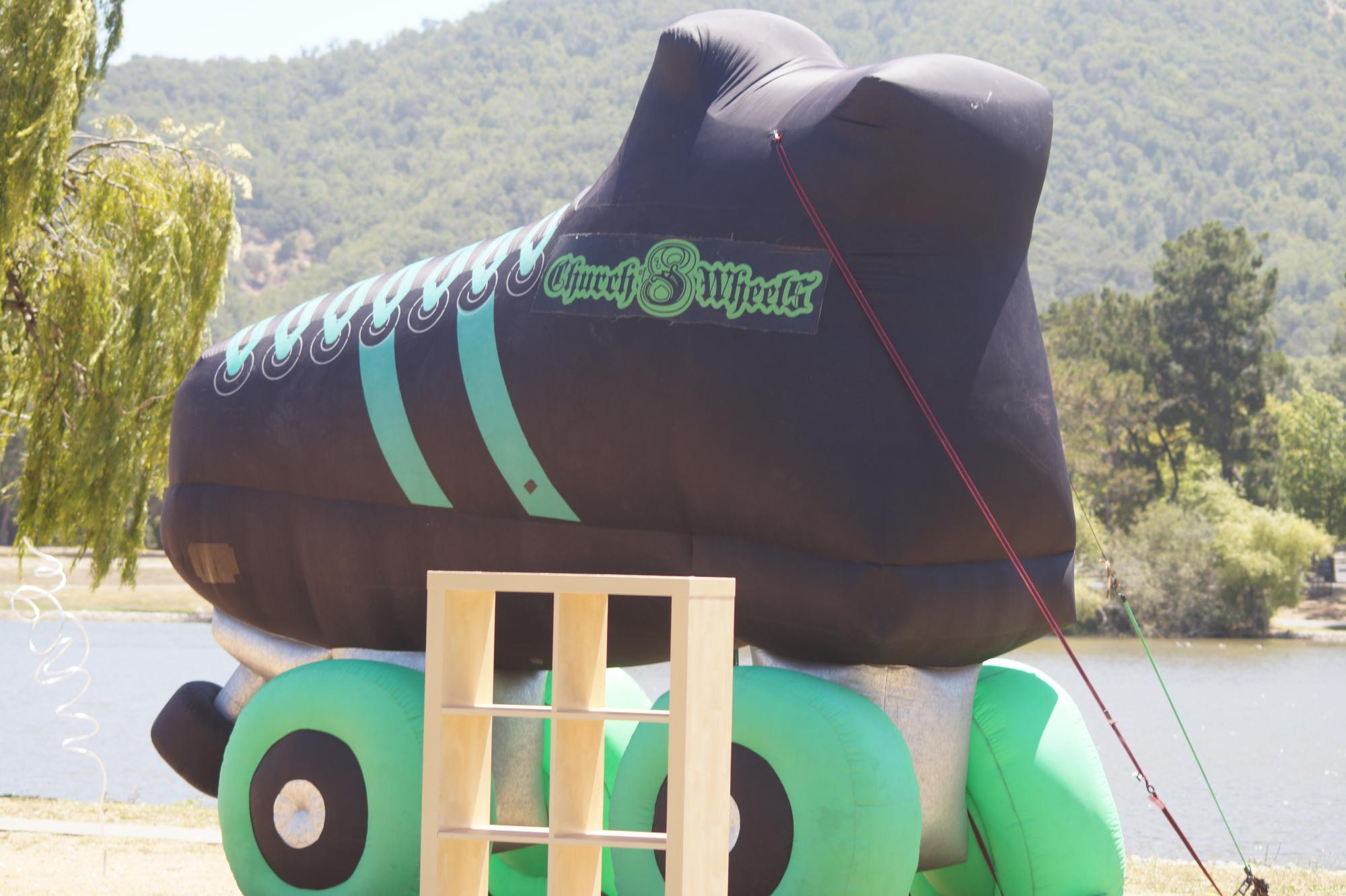 Large inflatable black and green roller skate for photo opportunities.