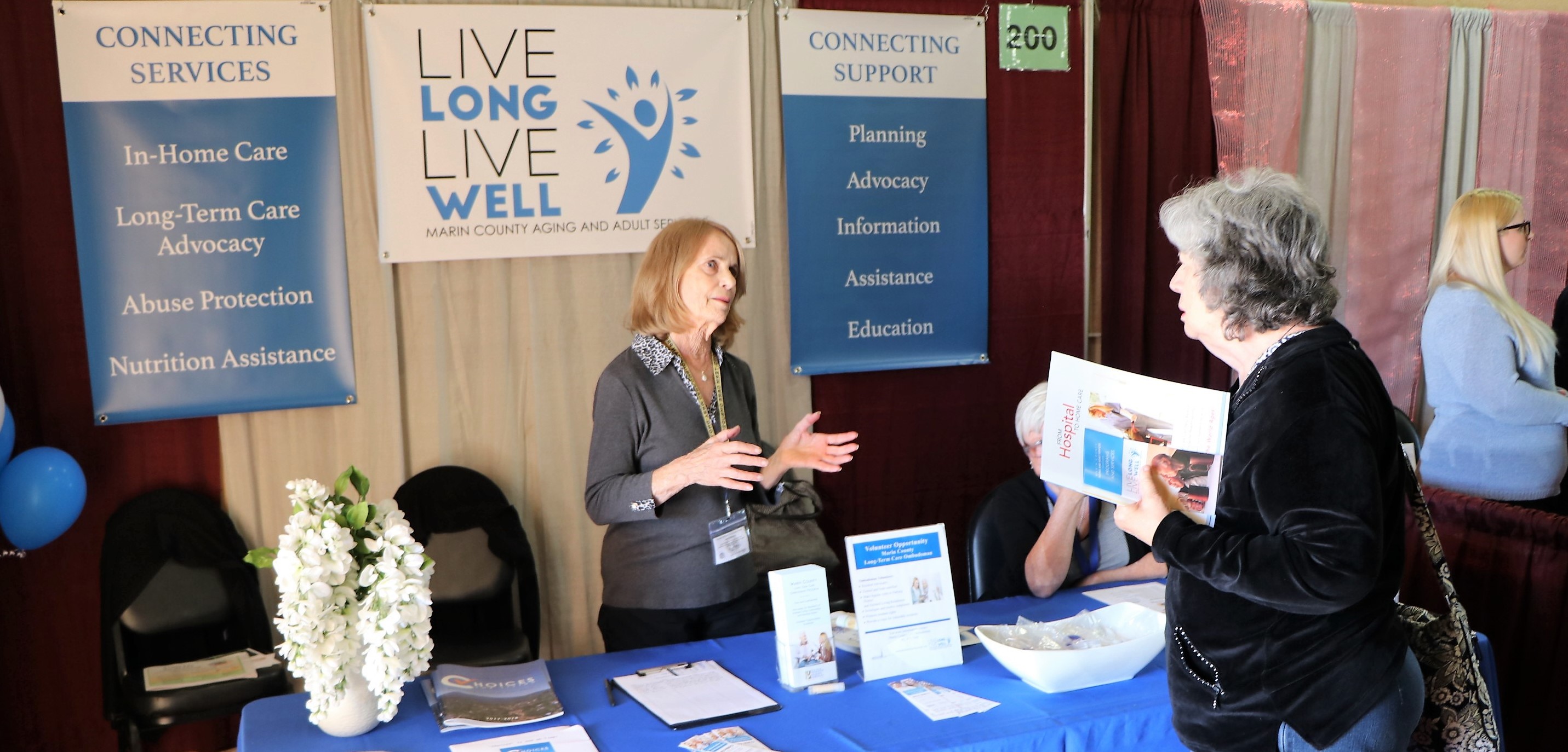 A woman from Aging and Adult Services Division speaks with another woman at the Marin Senior Fair.