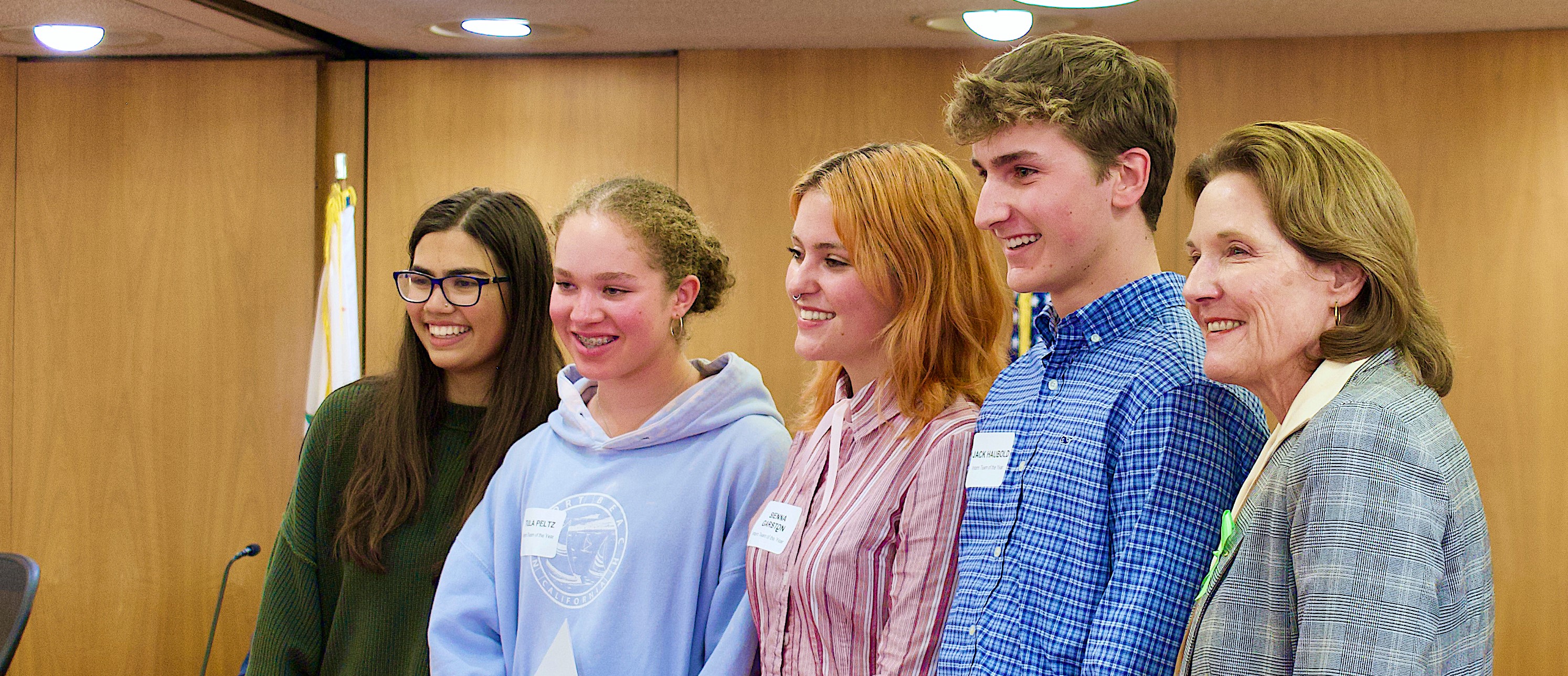 Four young interns smile as they stand next to Board of Supervisors President Stephanie Moulton-Peters