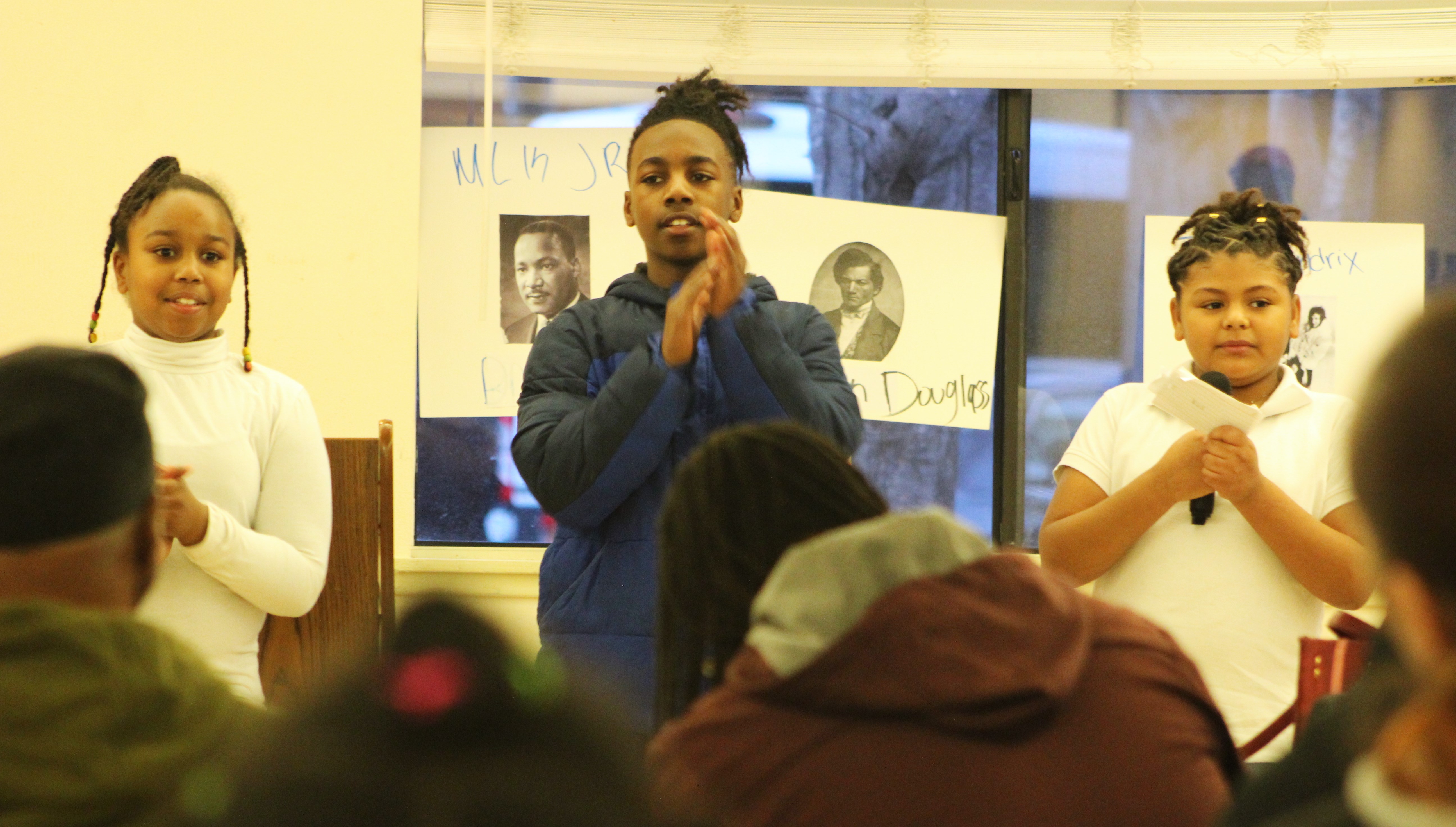 Three children perform during a Black History Month event.