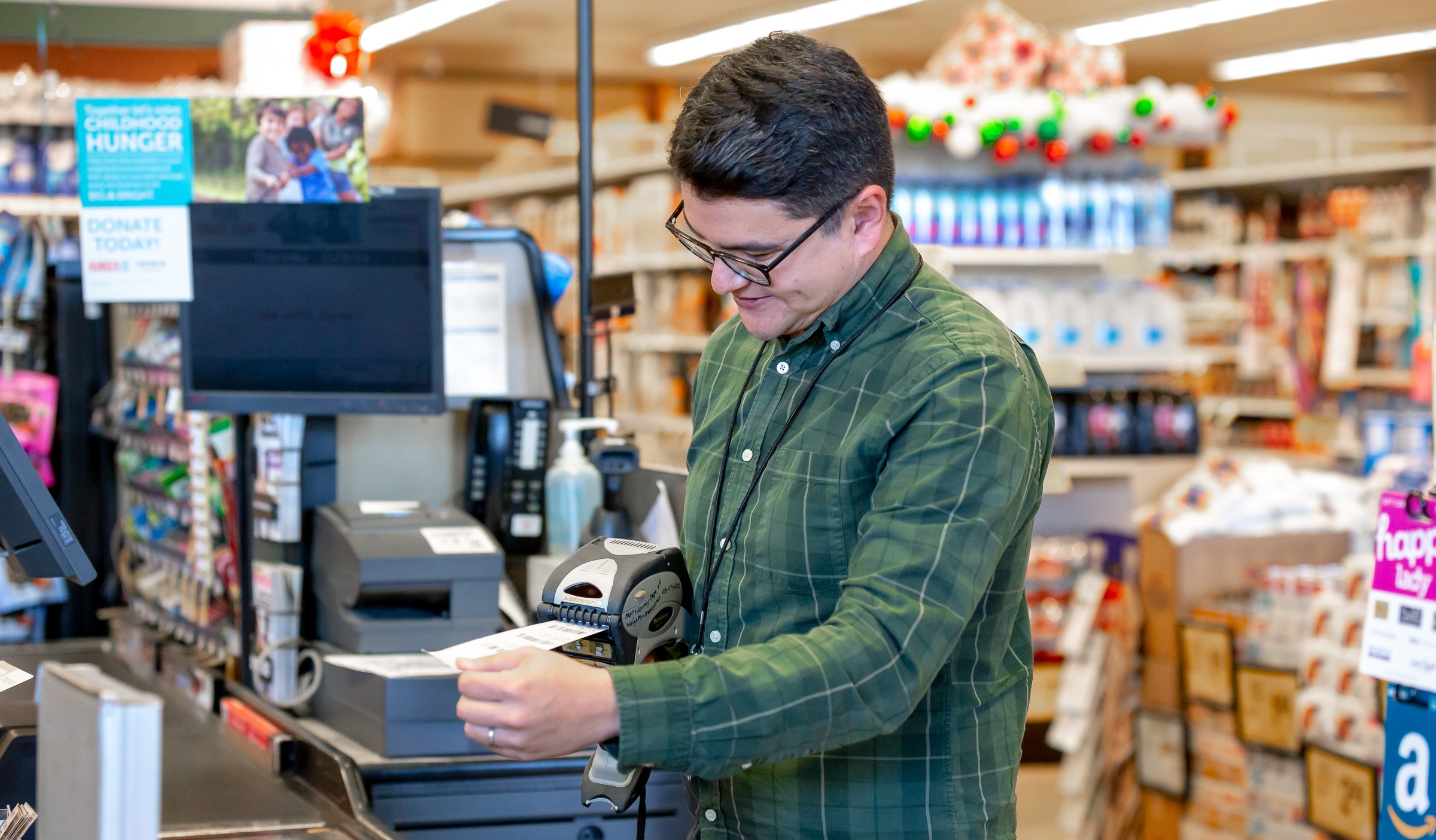 A male inspector checks the price of a product inside a store.