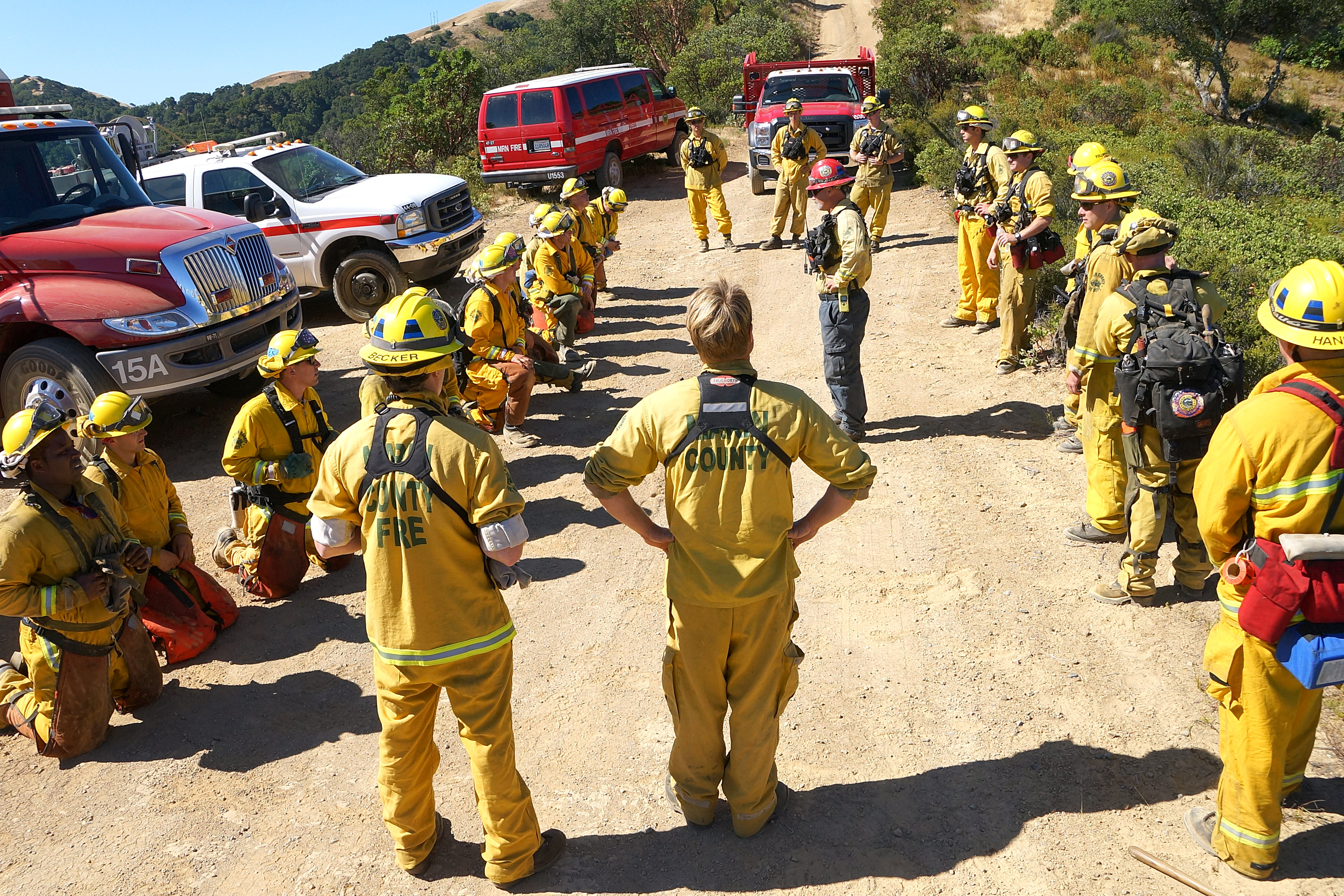 A group of firefighter trainees prepare for practice drills on a Marin hillside.