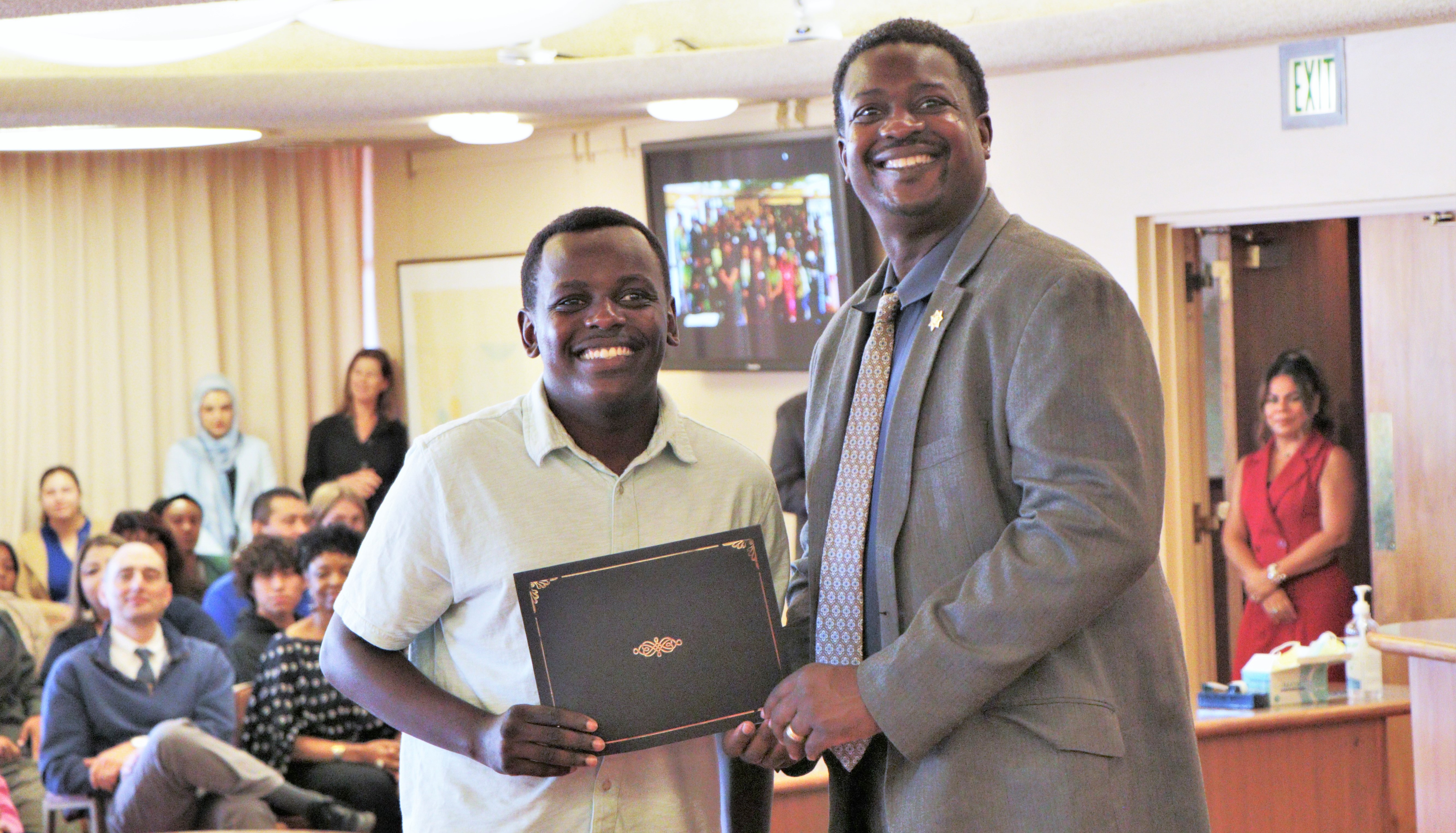 Career Explorers participant Wambua Misyoki smiles as he receives a certificate from Probation Chief Marlon Washington.