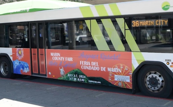 A bus with a County Fair advertisement on the side.