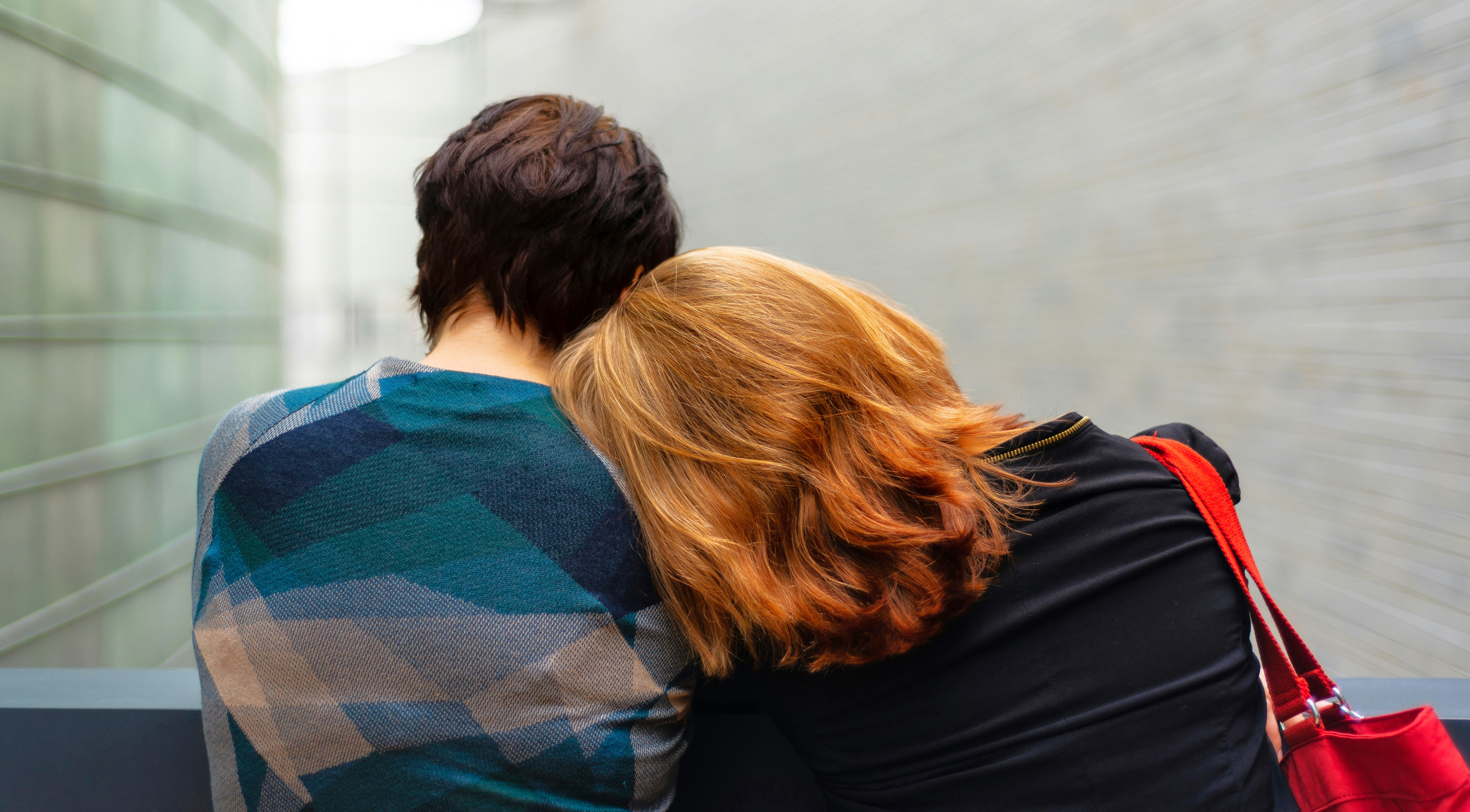 A teen boy and his mom sit together.