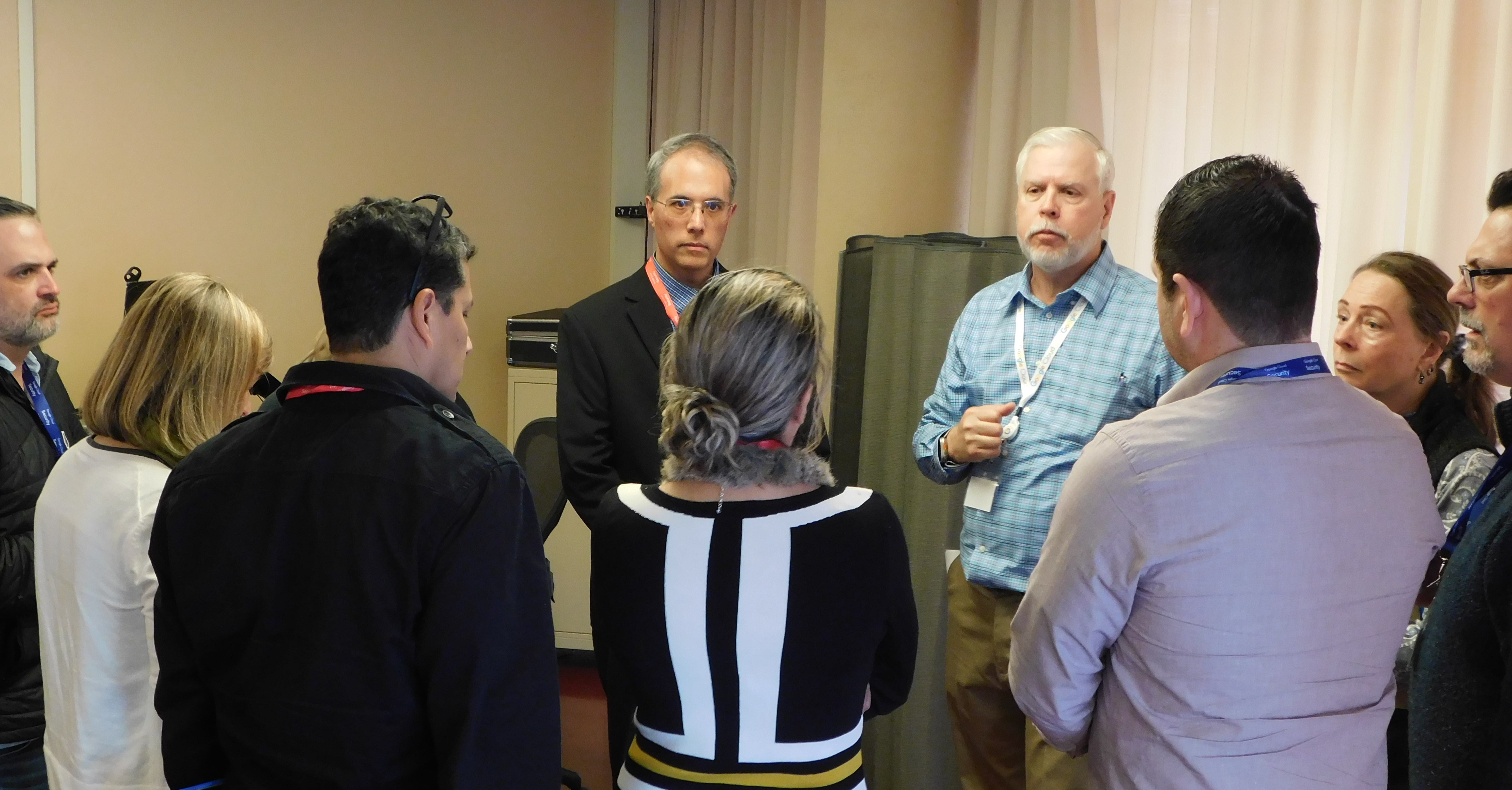 A group of people talk about cybersecurity.