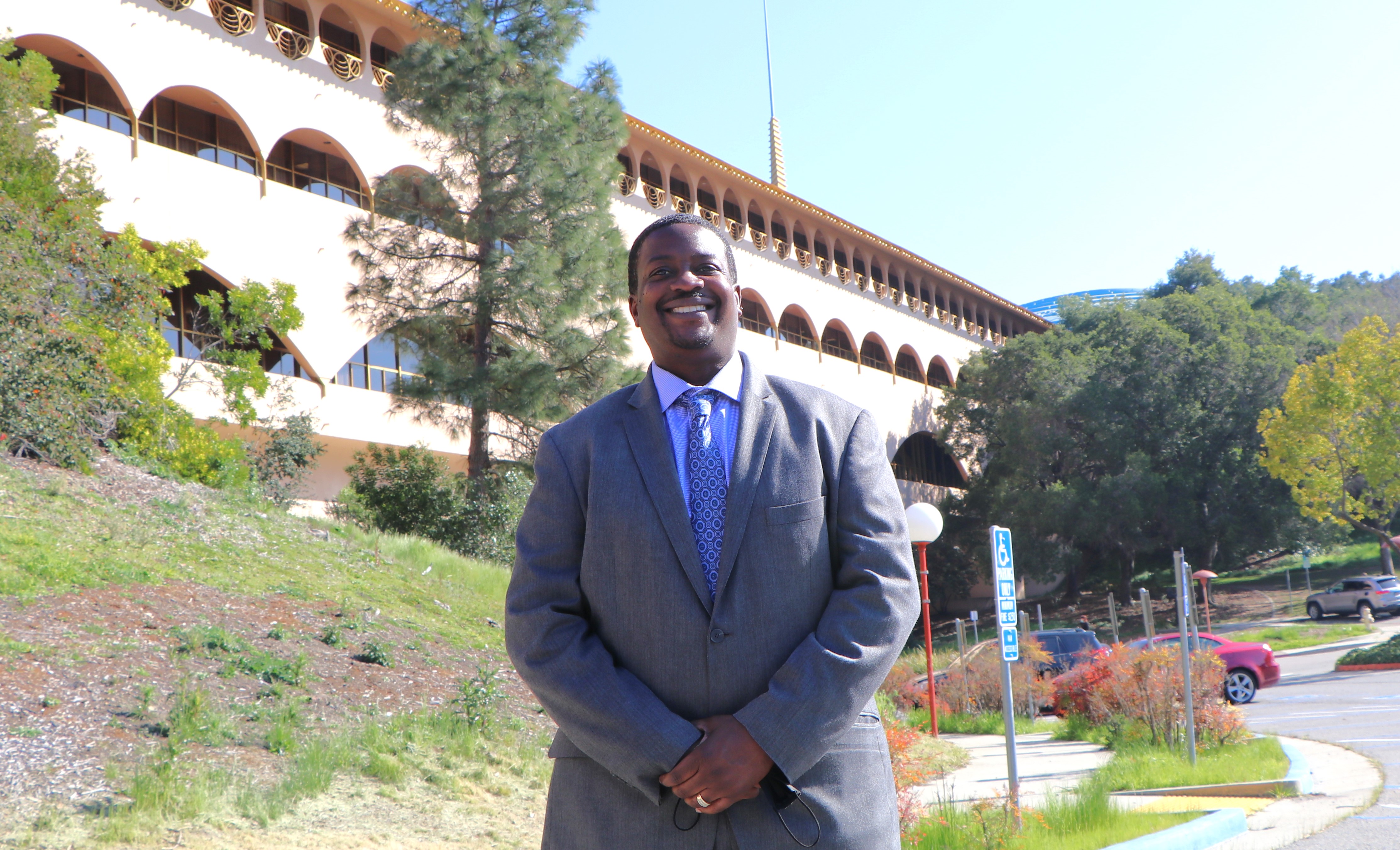 Marlon Washington stands and smiles with the Marin County Civic Center behind him.