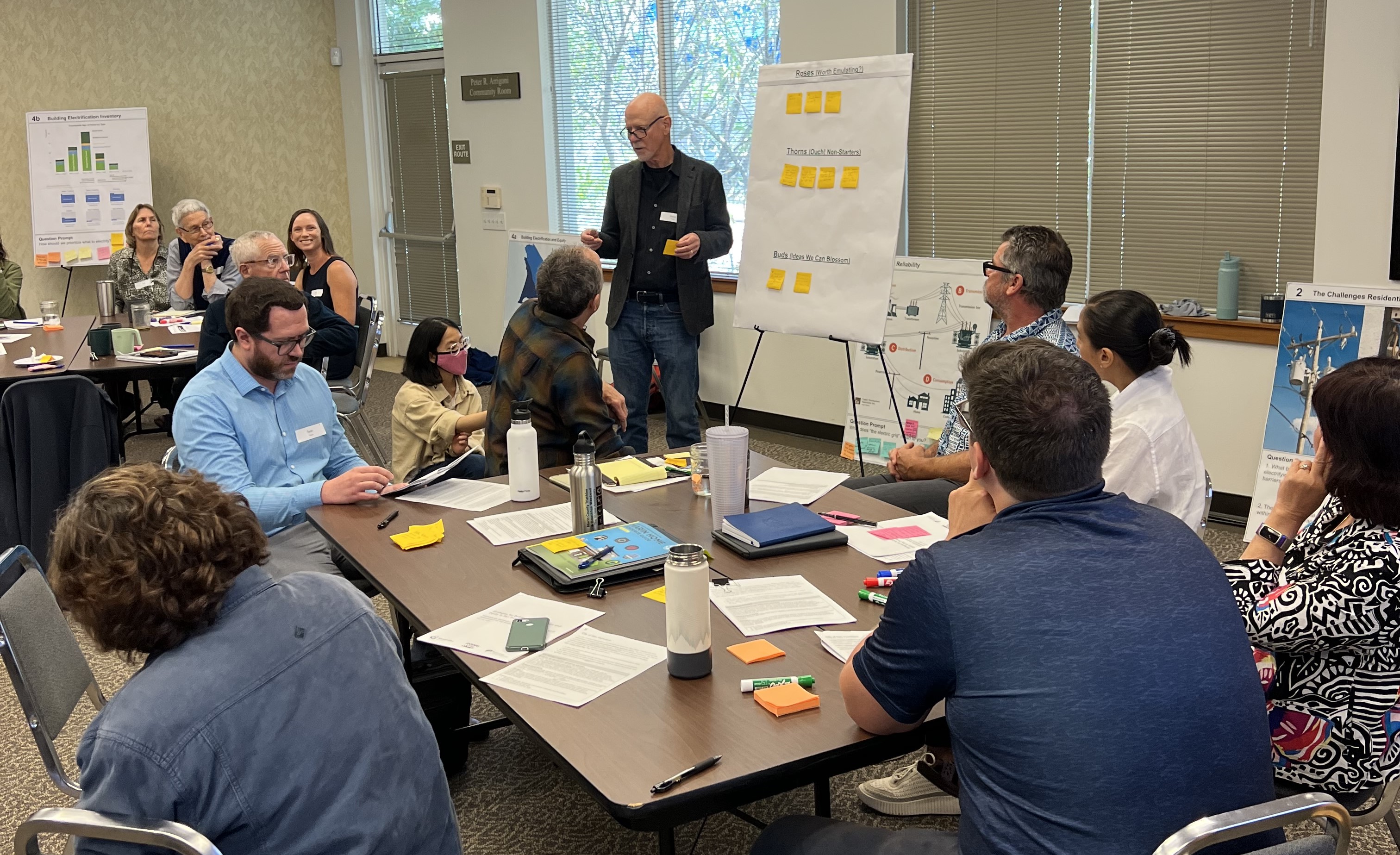 About 10 people in a meeting room talking about electrification.