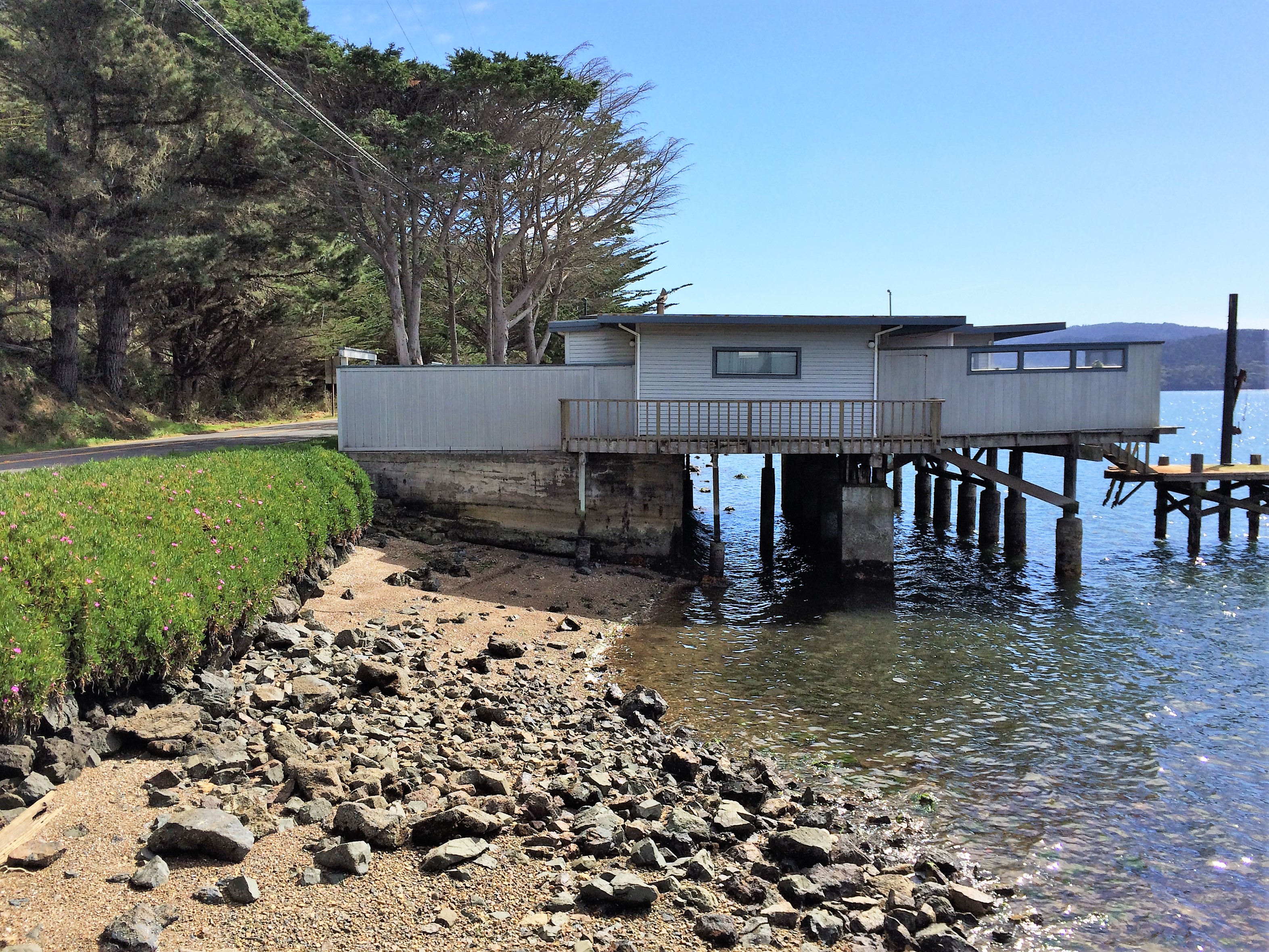 A home on stilts hanging over the waters of Tomales Bay.