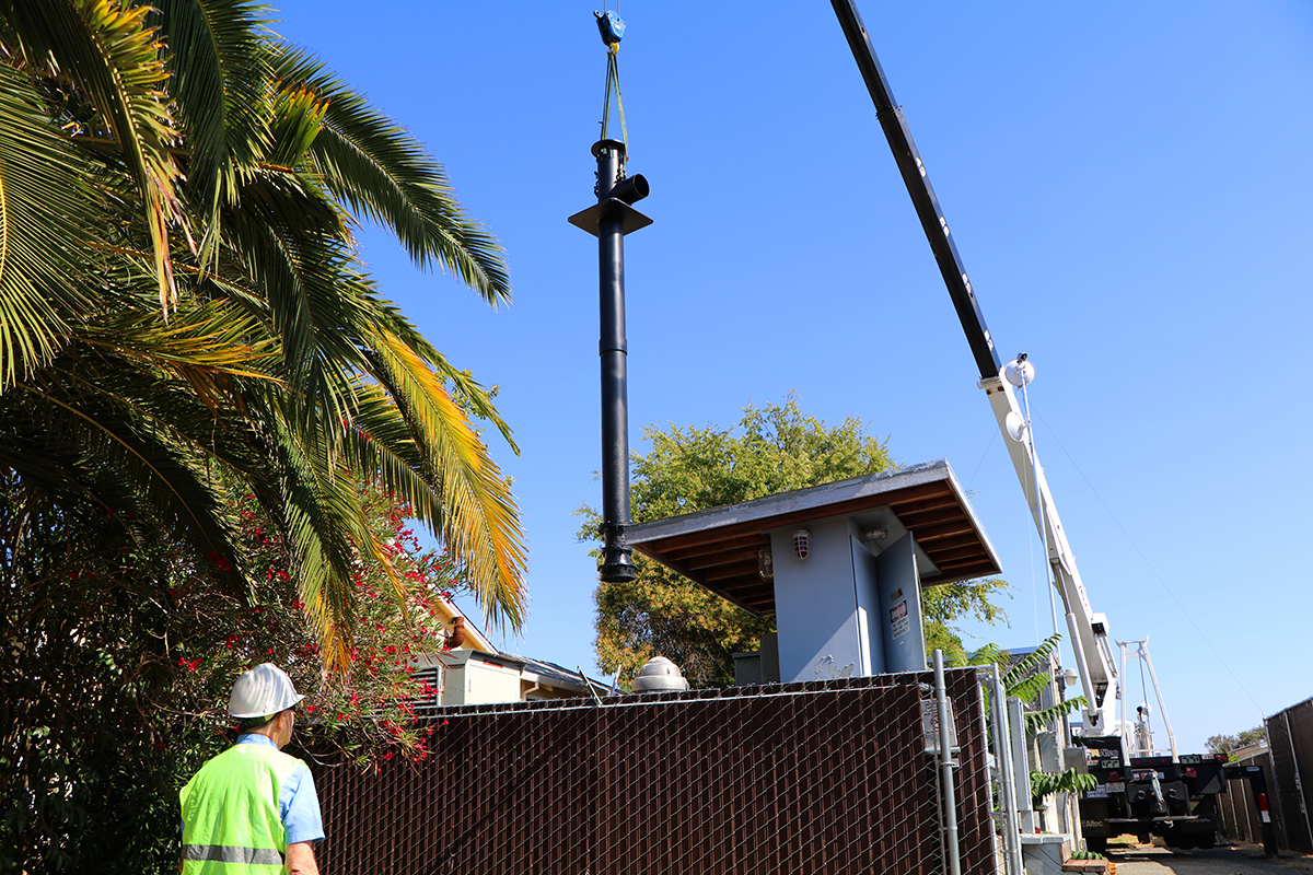 A crane operator lowers a new pump at a neighborhood pump station.