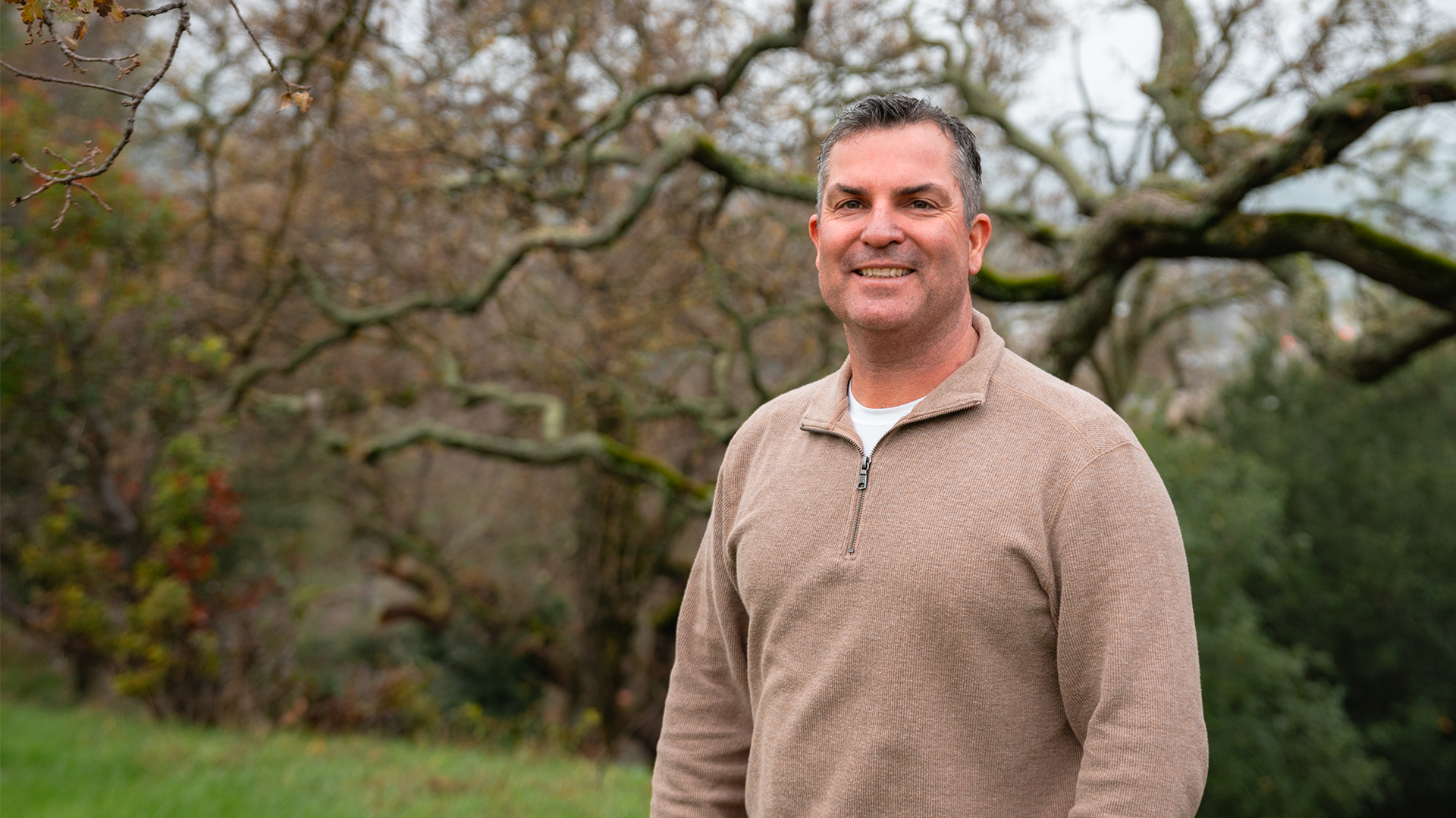 Chris Chamberlain stands in front of a legacy oak tree