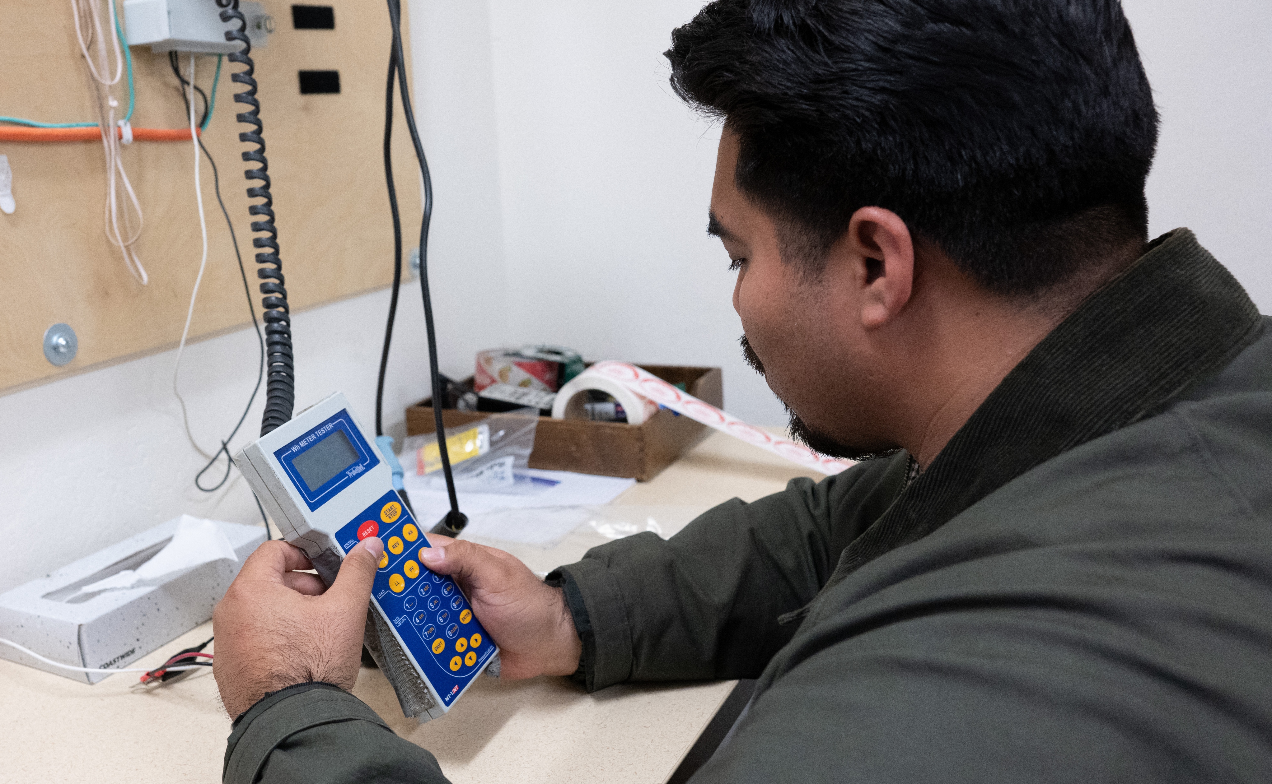 An inspector checks a hand-held electronic device.