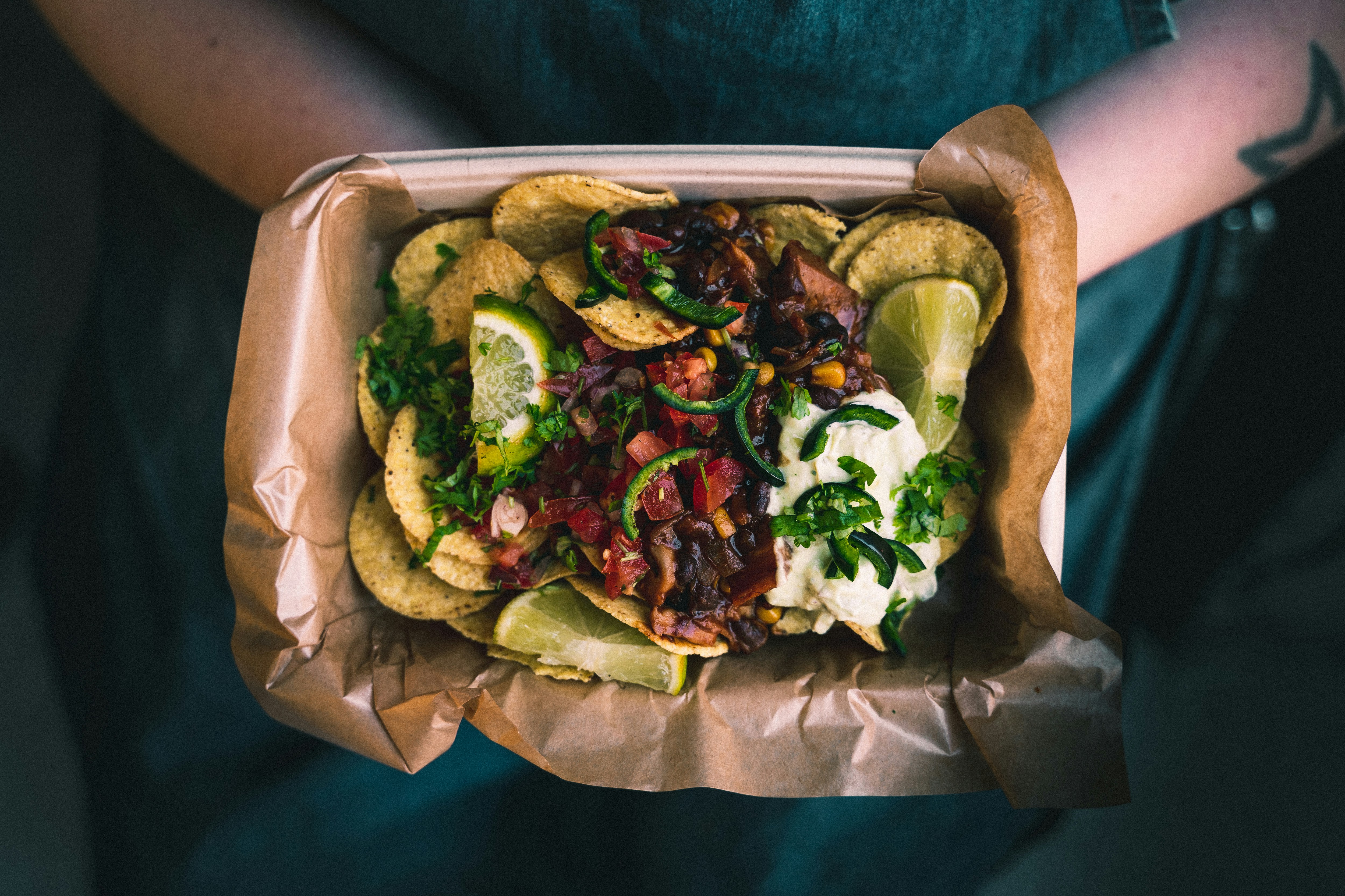 A closeup view of a person's hands holding a plate of dinner.