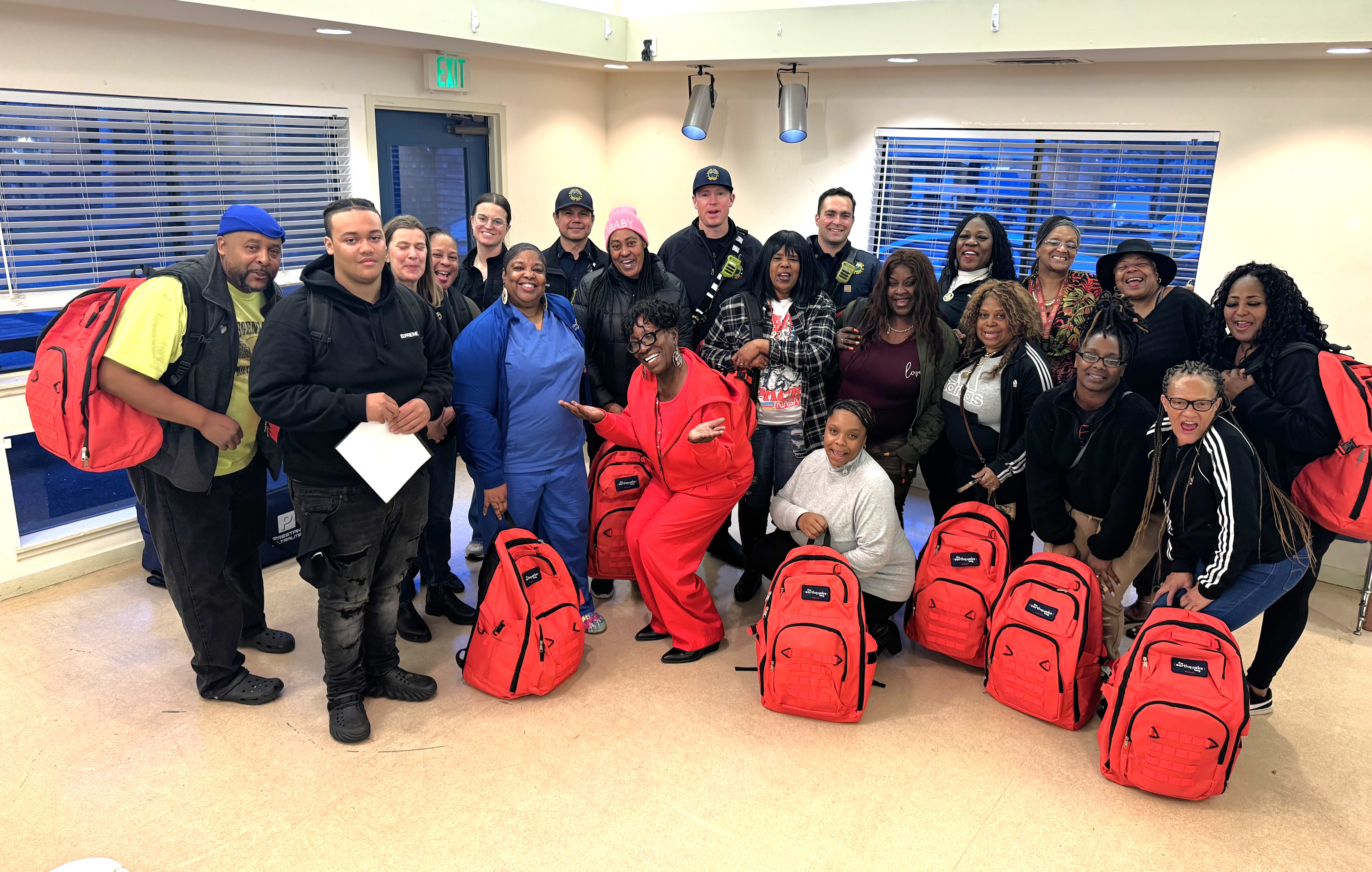 About 25 people pose with go-bags after an emergency training.
