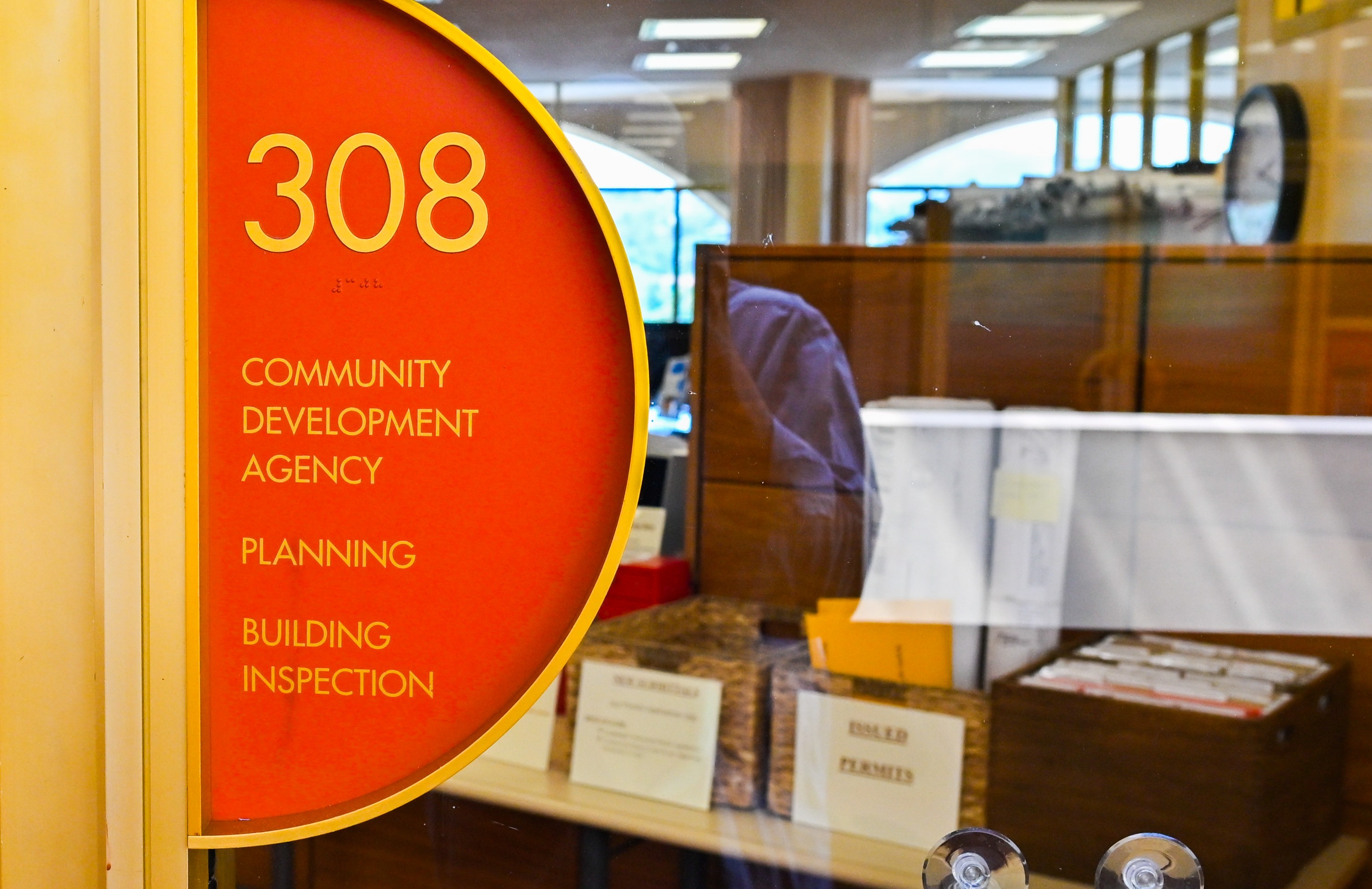 Signage the door outside the Community Development Agency with a peek at desks inside.
