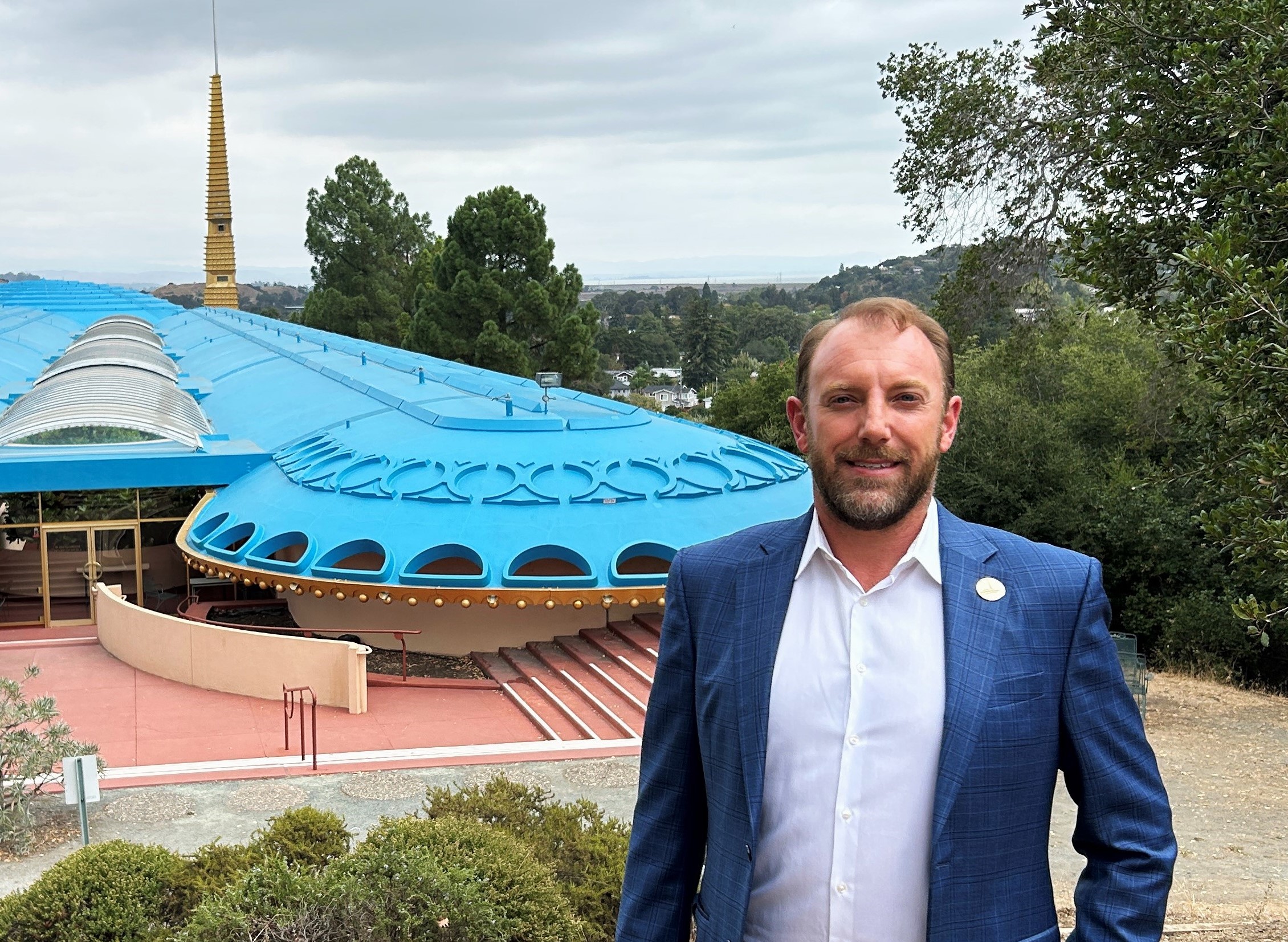 Christopher Blunk stands on a hillside with the Marin County Civic Center in the background.