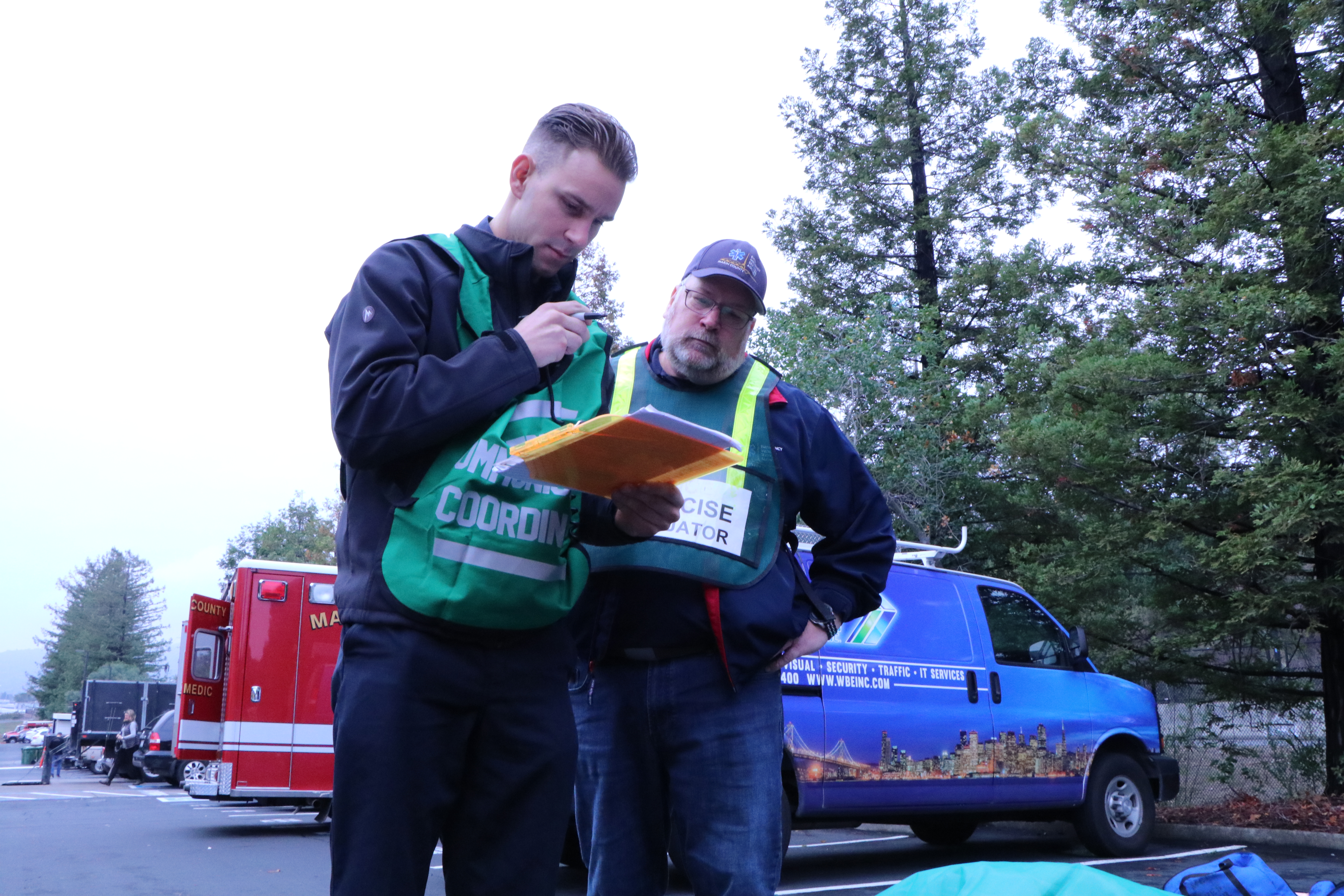 Two men look at a clipboard during a disaster preparedness exercise.