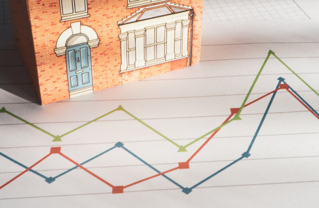 Artistic graphic shows a graph of jagged lines with a house in the background.