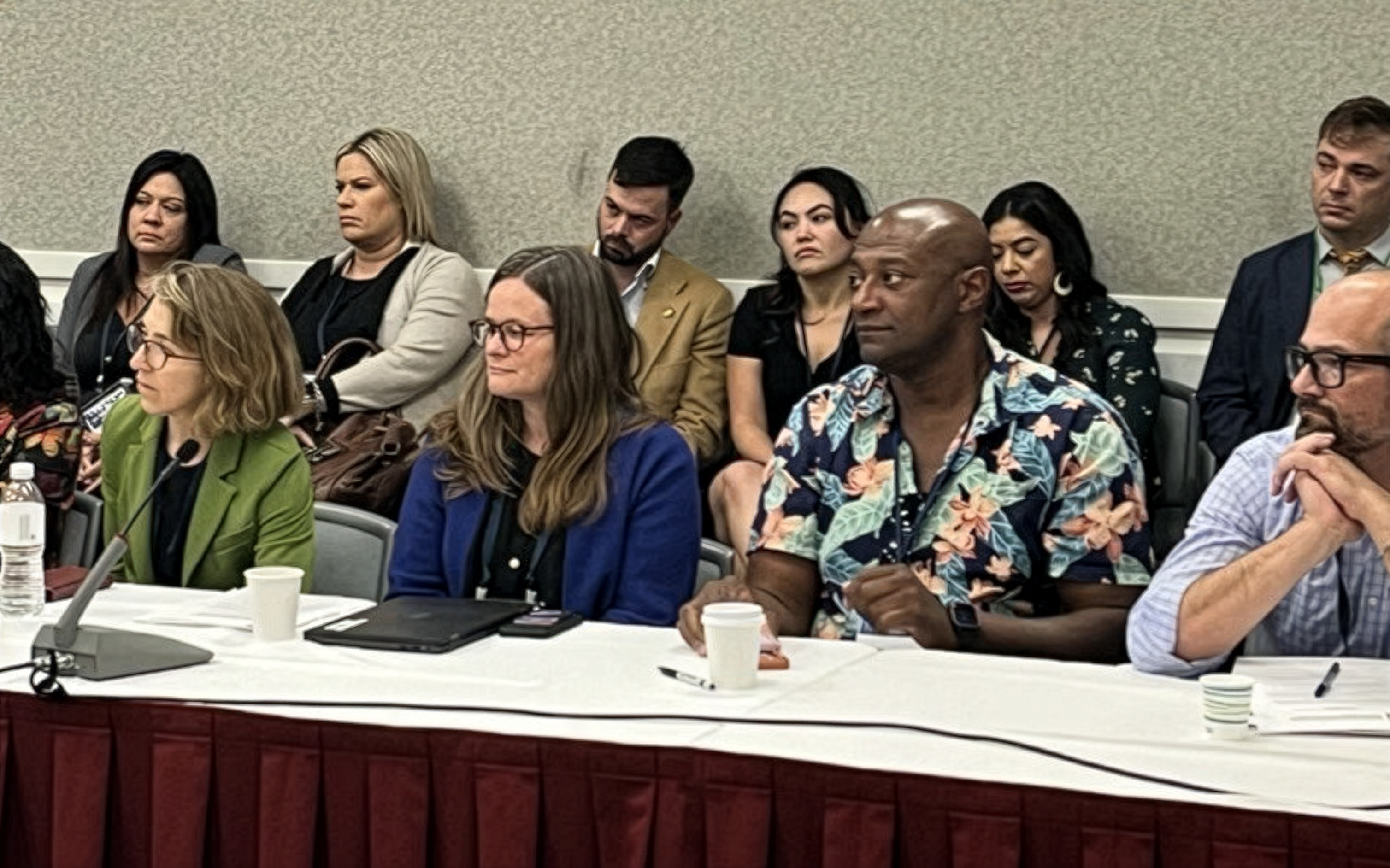 A group of people at a conference table includes two members of the Board of Supervisors.
