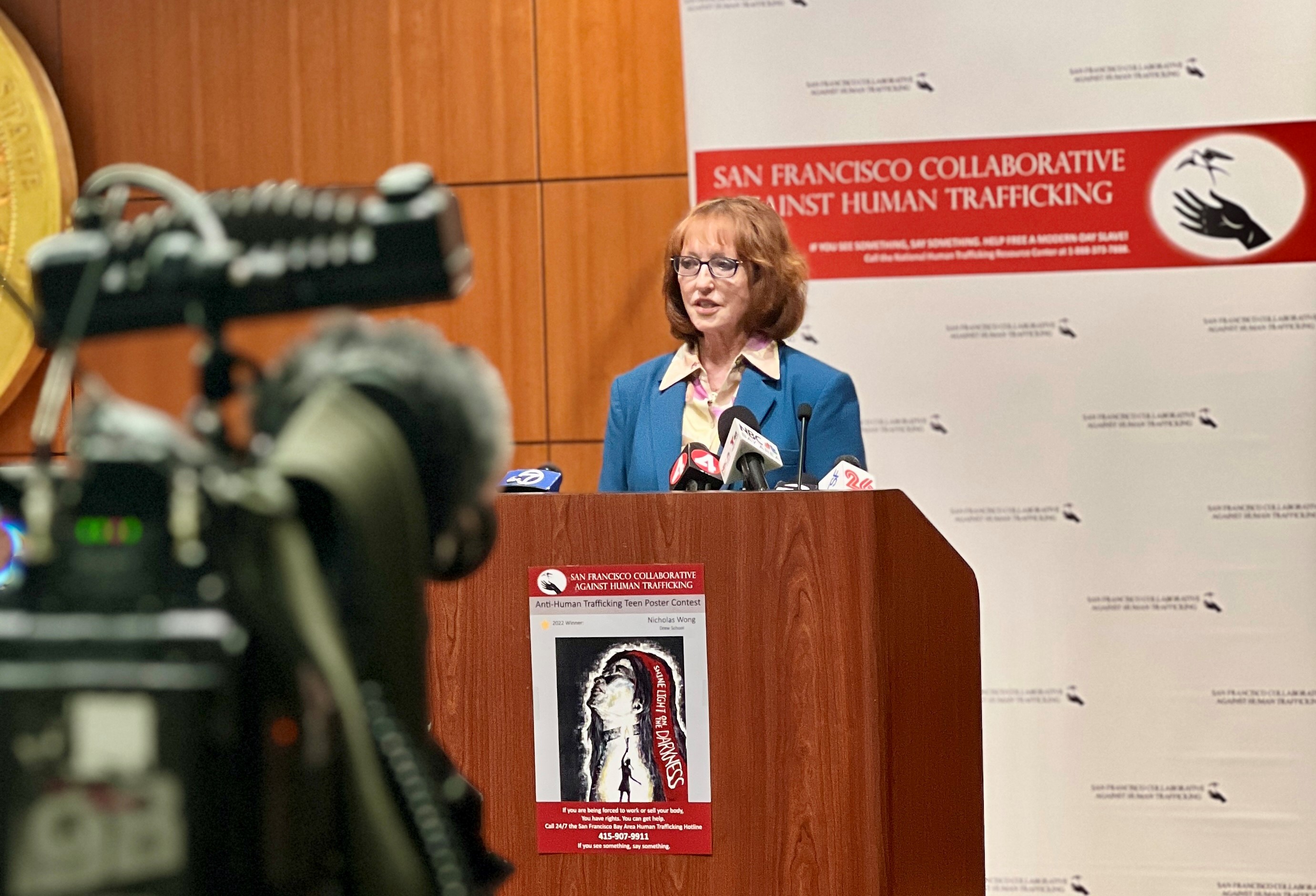 District Attorney Lori Frugoli speaks into a microphone at a press conference.