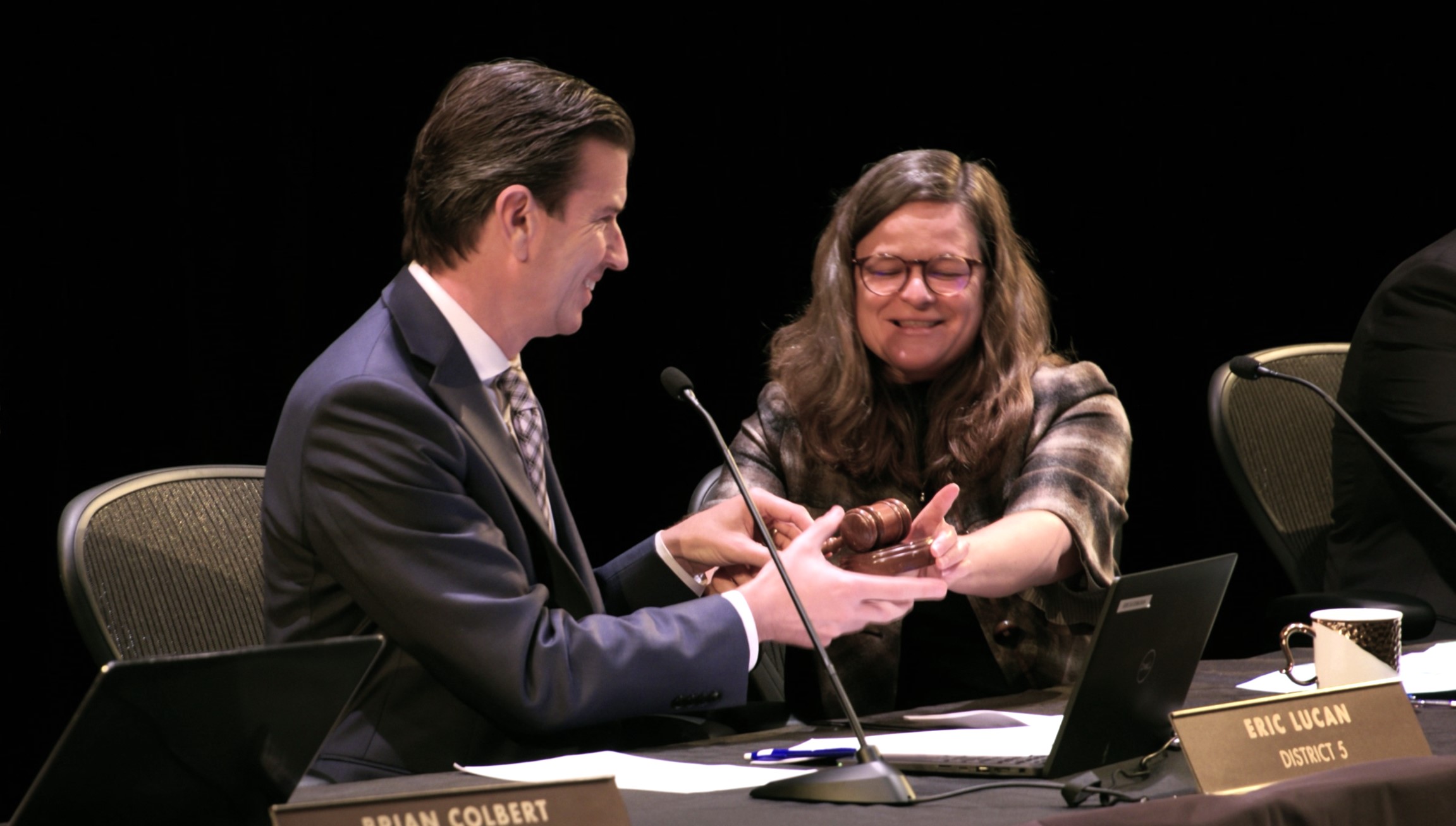 Eric Lucan, left, accepts the gavel from Mary Sackett during the Board of Supervisors meeting.