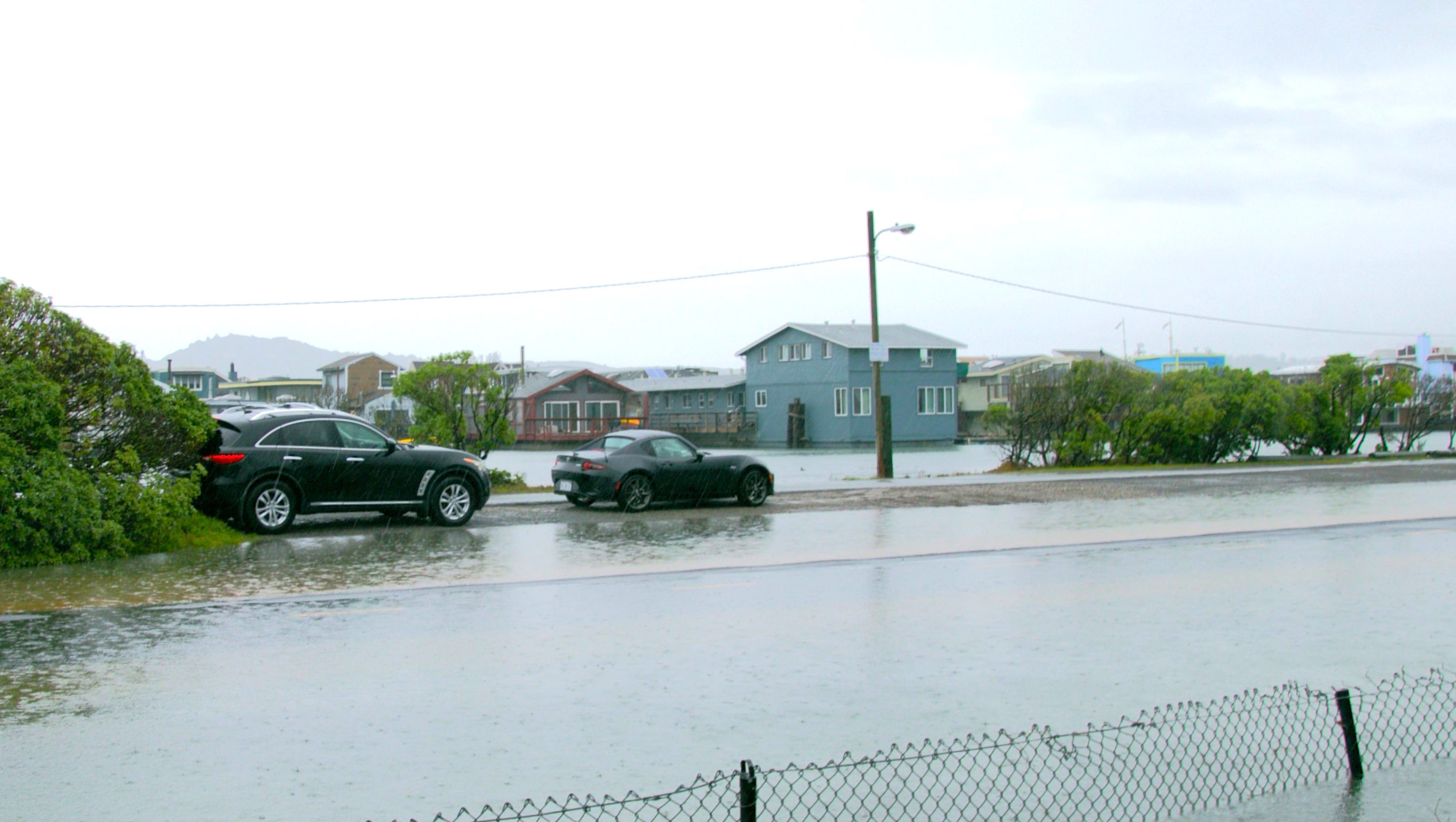 Cars stuck on a flooded roadh in high waters from king tides and heavy rain.