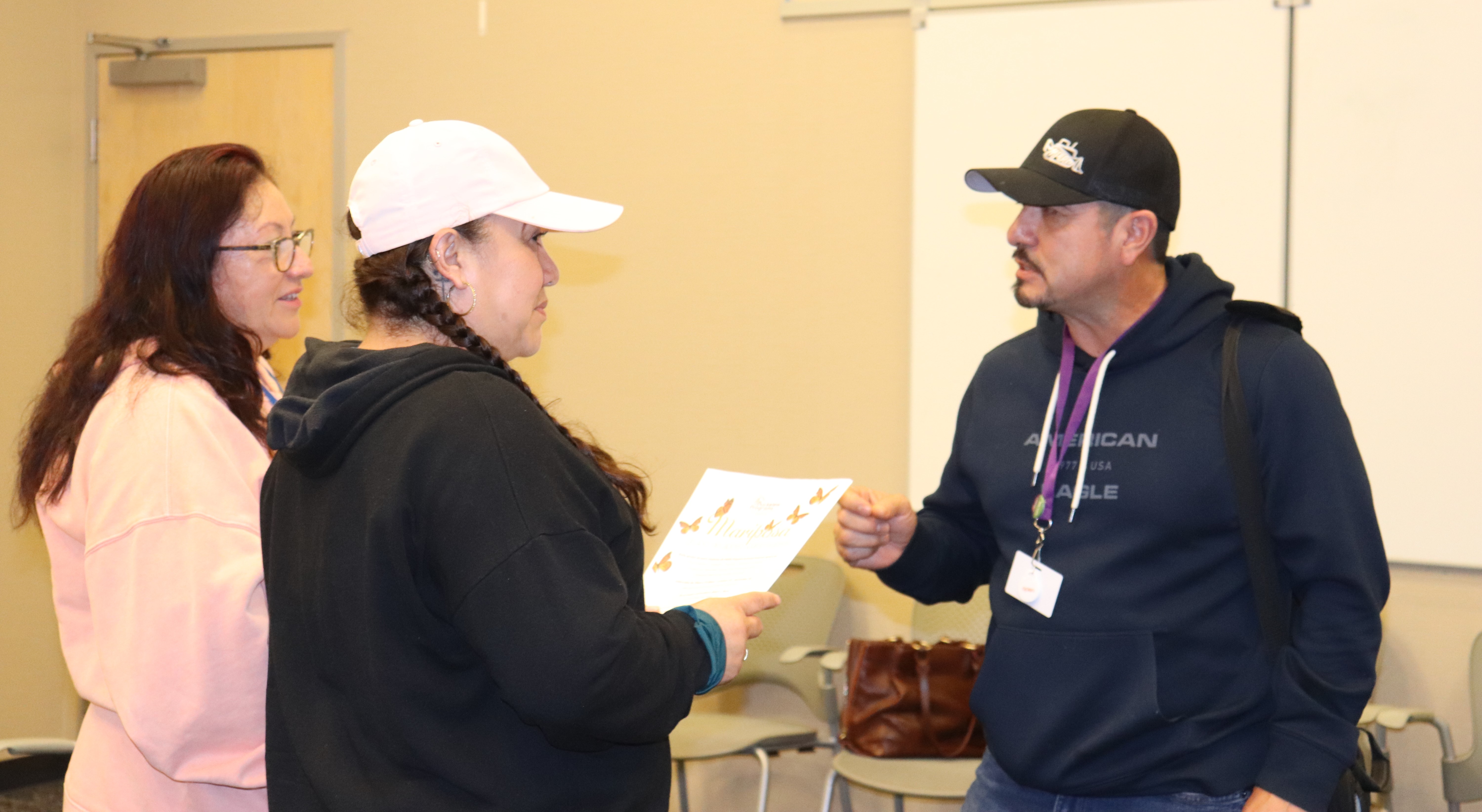 A man speaks with two women about receiving services.