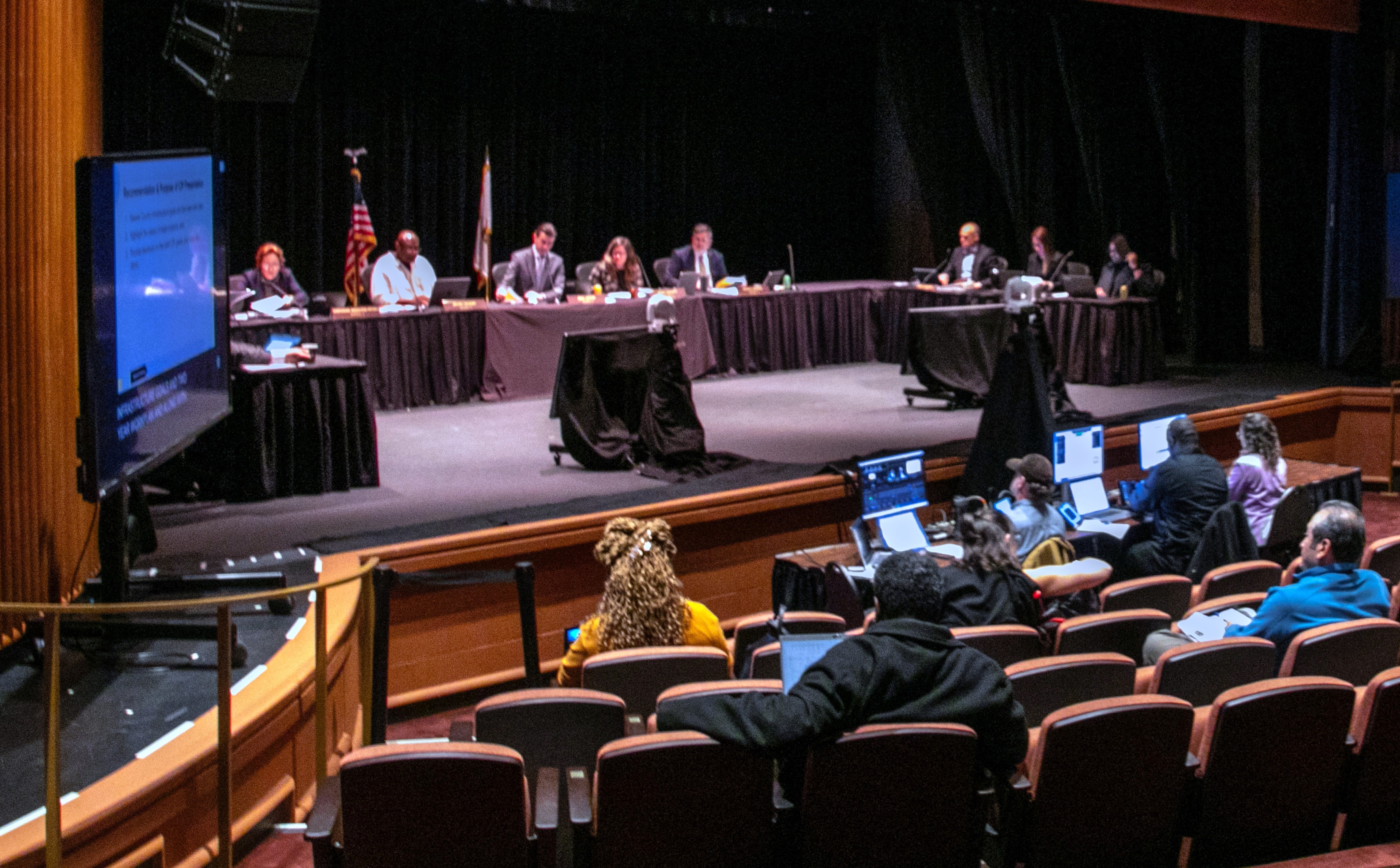 The Board of Supervisors conducts business during a meeting in the Showcase Theater with a few people in the audience.