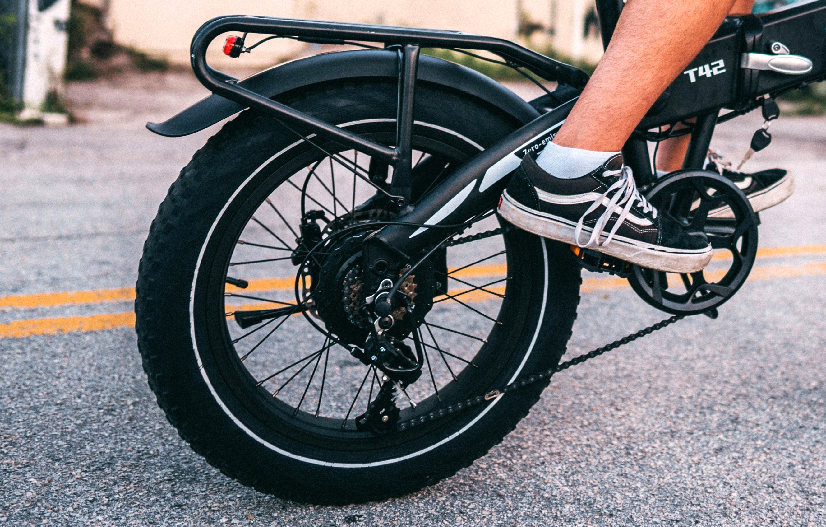 Close-up view of the chain and wheels of a bike being ridden by a person.