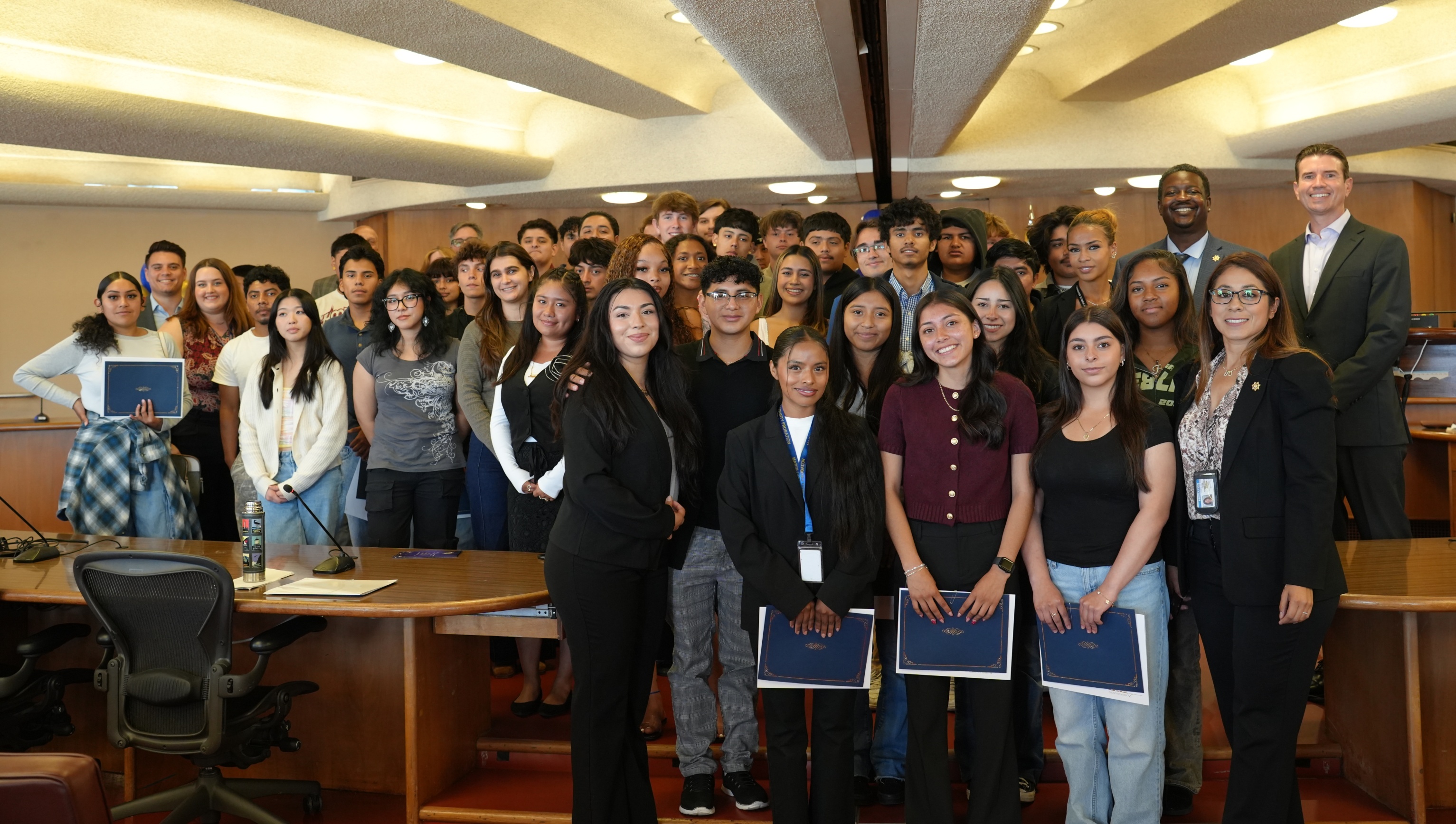About 20 Career Explorers and their mentors pose at a County Board of Supervisors meeting.