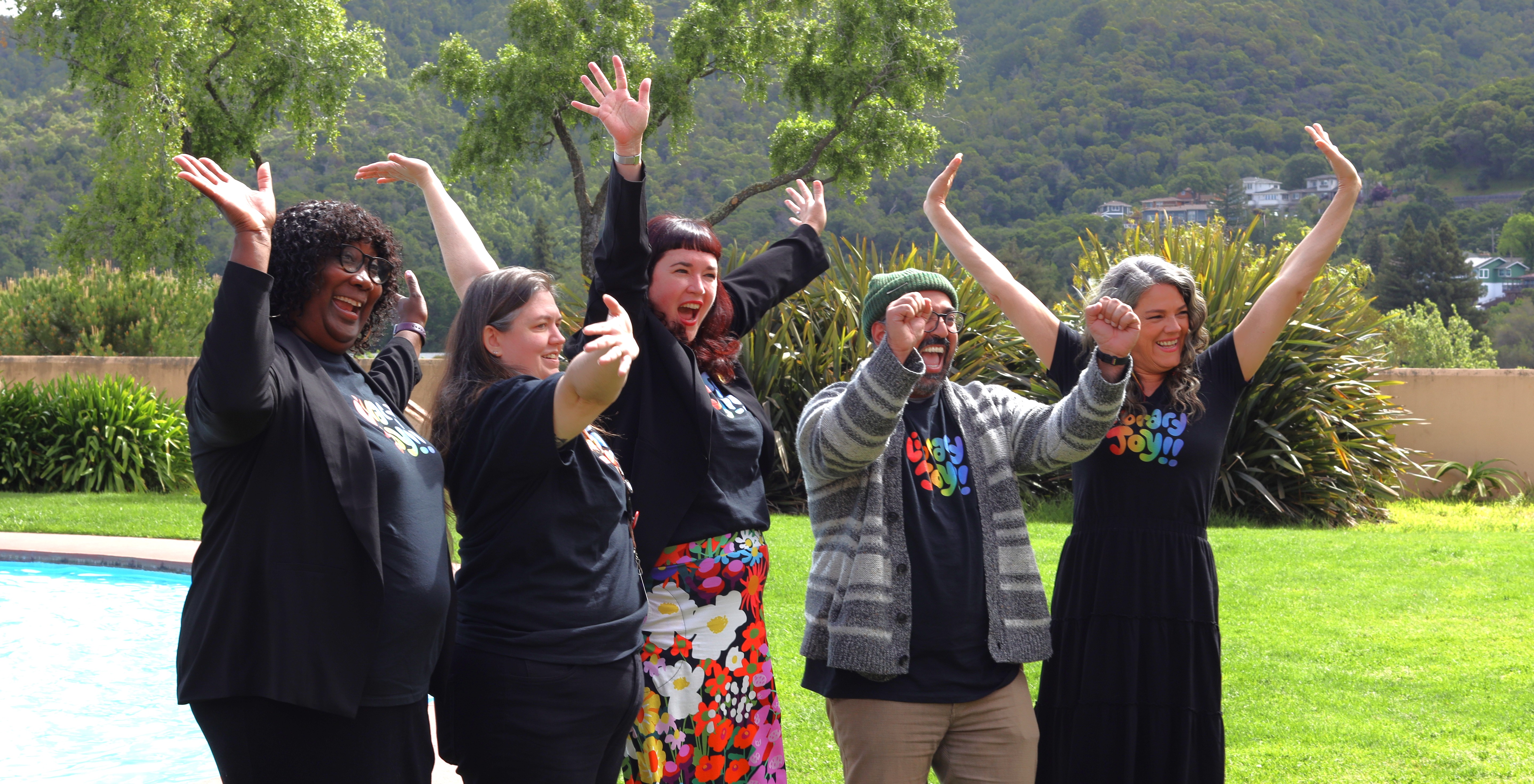 Five members of the library administration staff smile and wave.