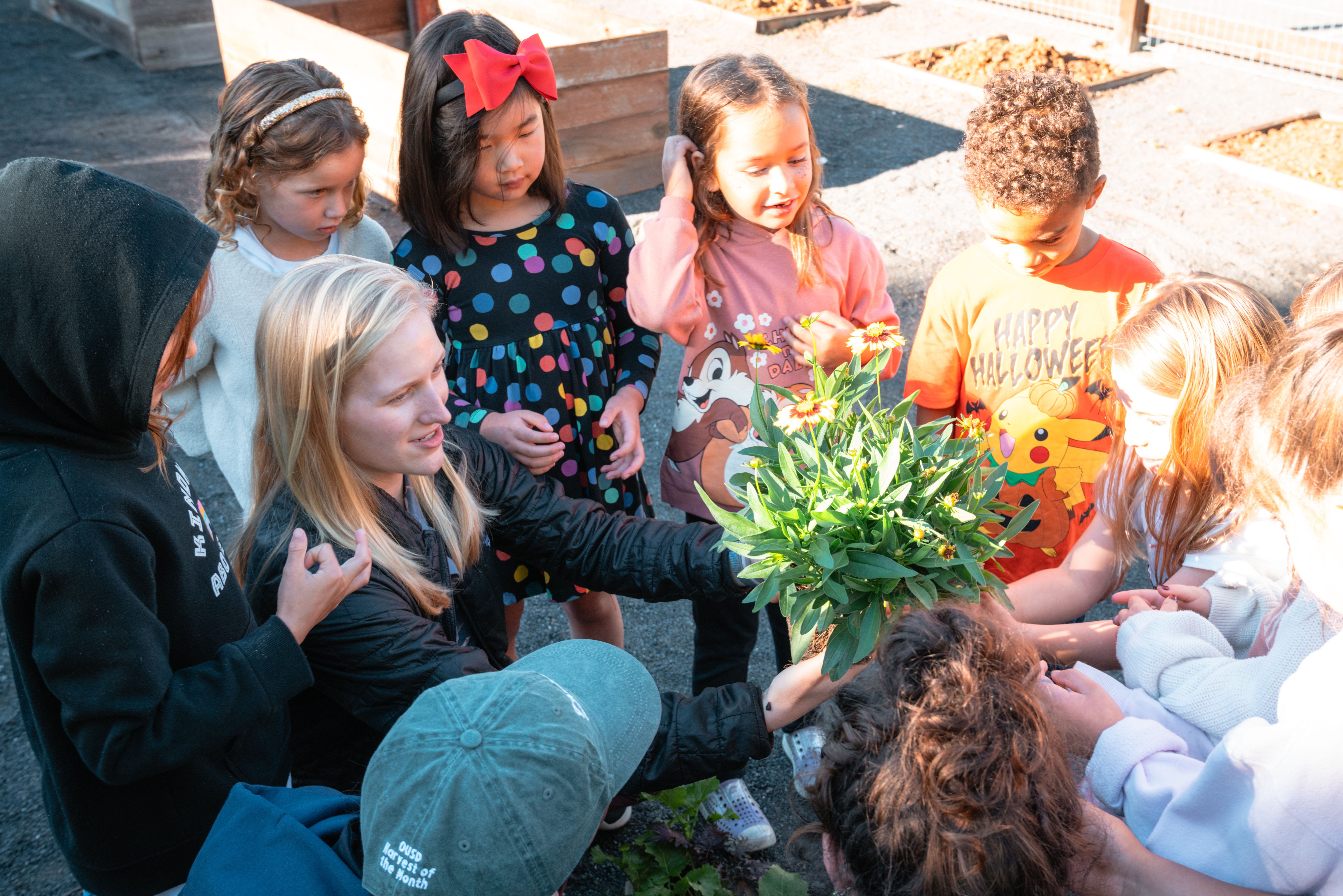 A woman is urrounded by kids during an educational field trip.