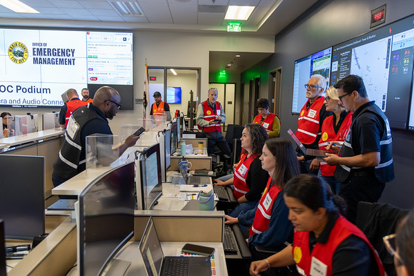 A bunch of people participate in an emergency training in the operations center.