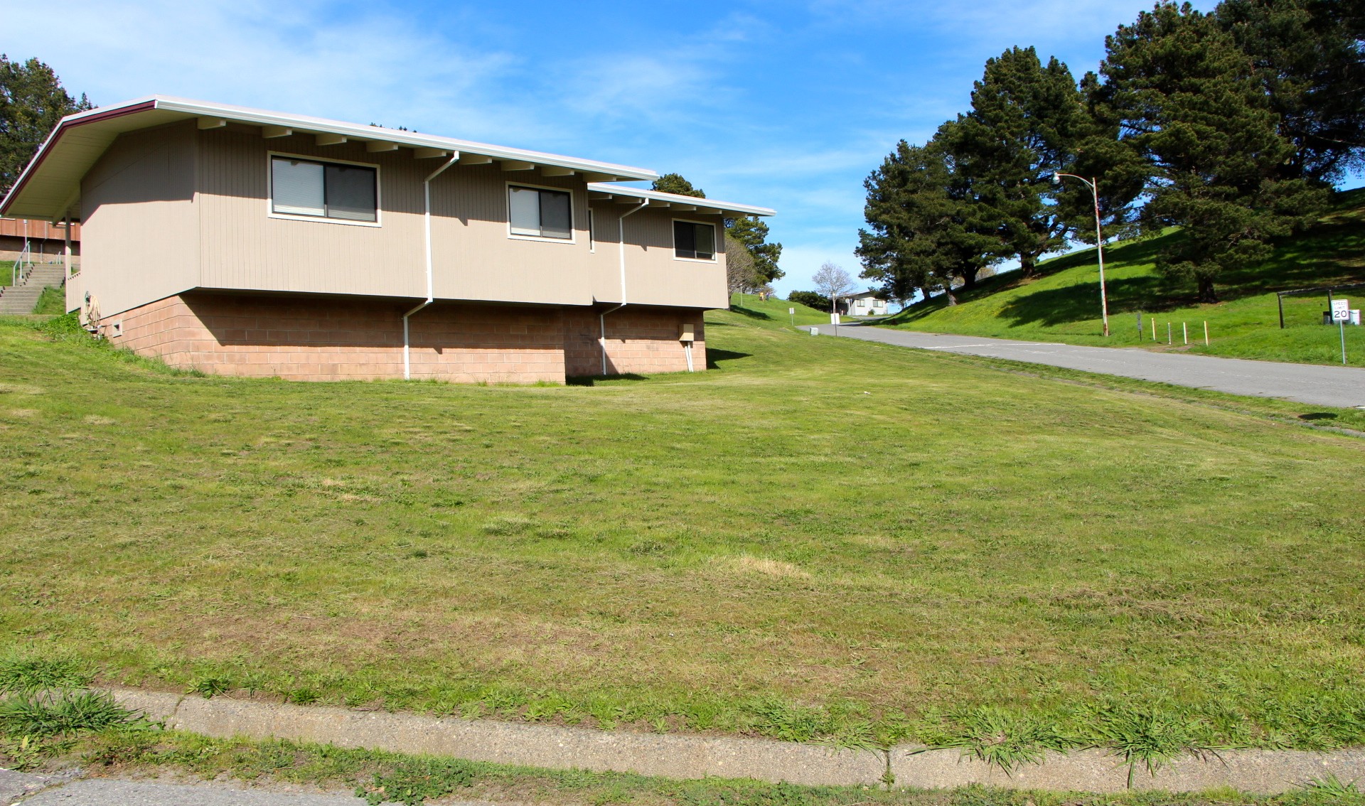 An old building at the former seminary property and an adjacent grassy hillside.