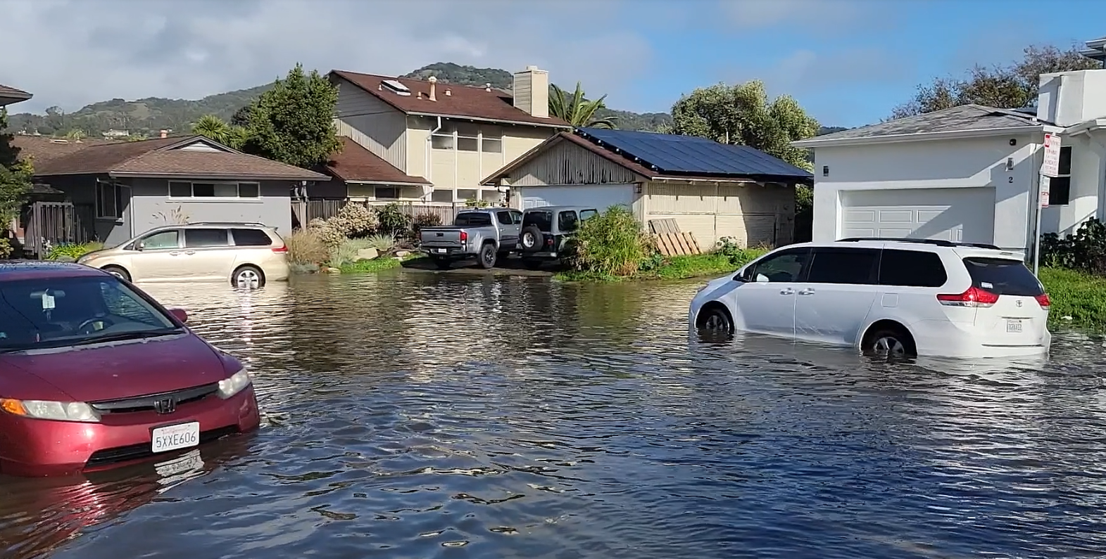 Cars stuck on a flooded road in high waters from king tides and heavy rain.