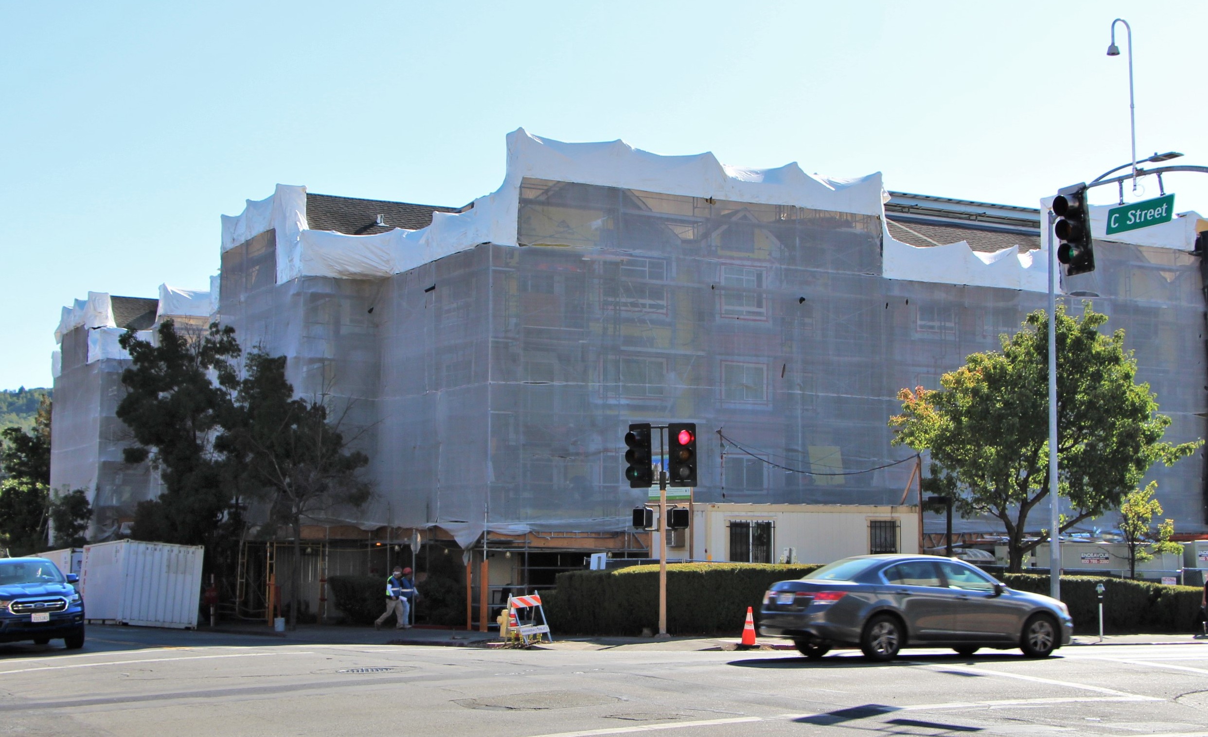 A multiunit housing development under construction, viewed by a street corner.