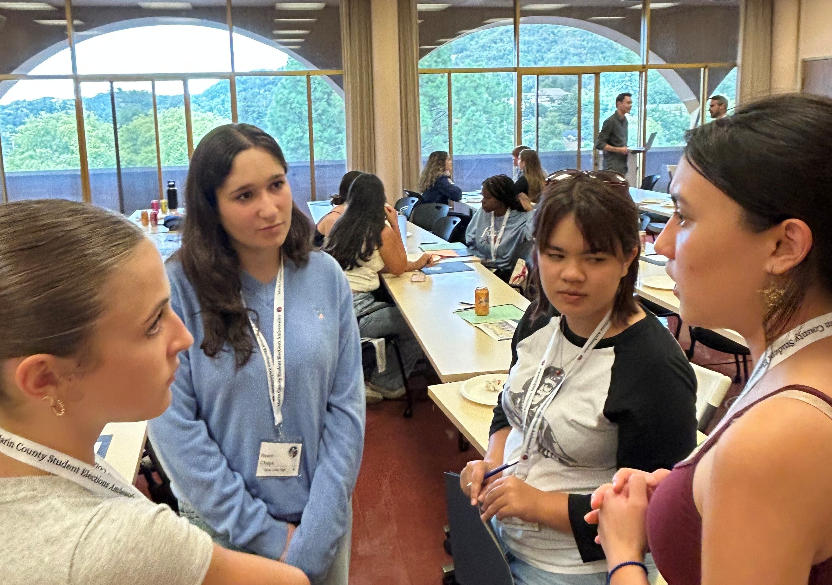 Four teenage girls talk about elections with more students in the background at last year's SEAP event.