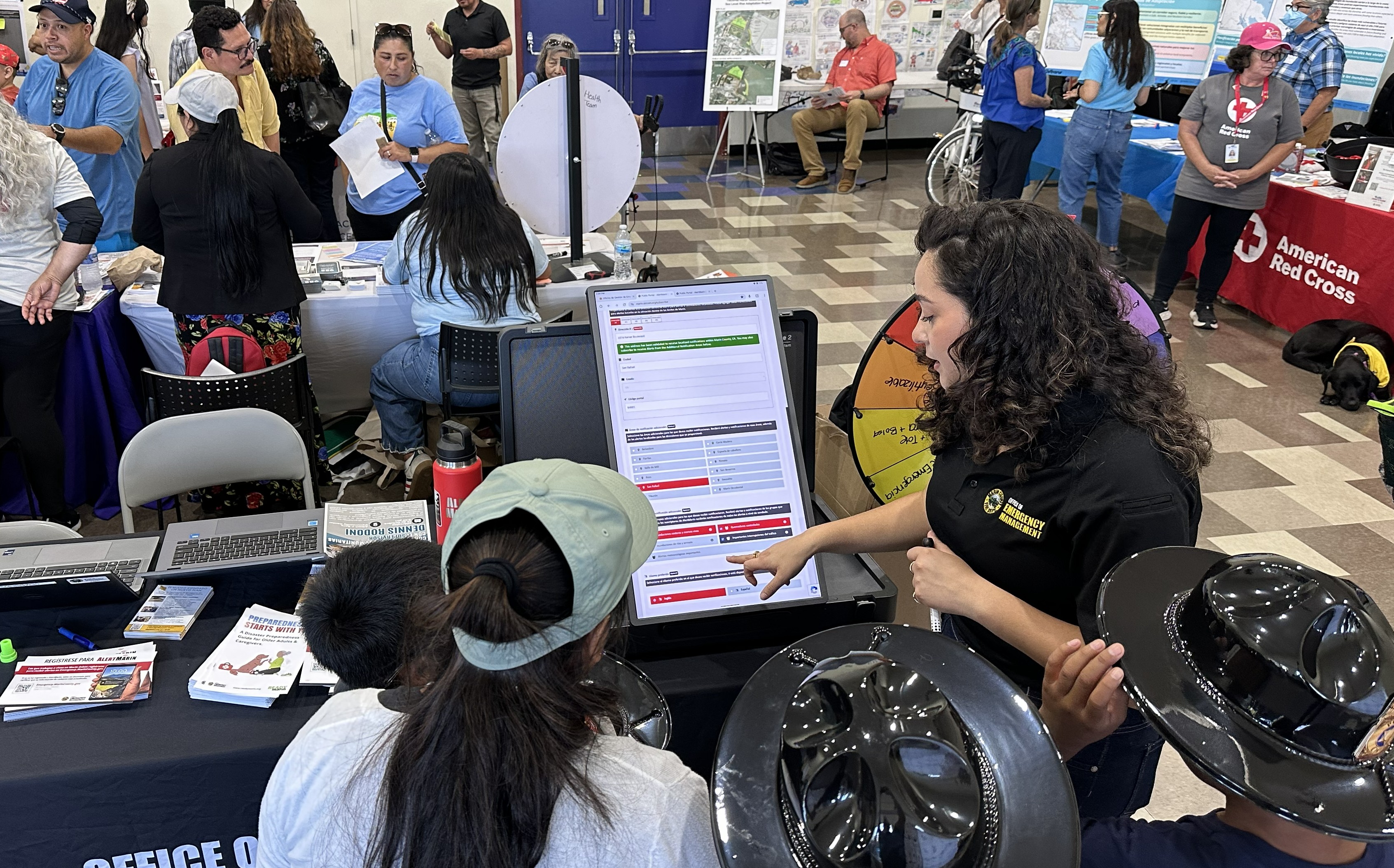A female Fire Department representative speaks to a group of kids about emergency preparedness during a fair.