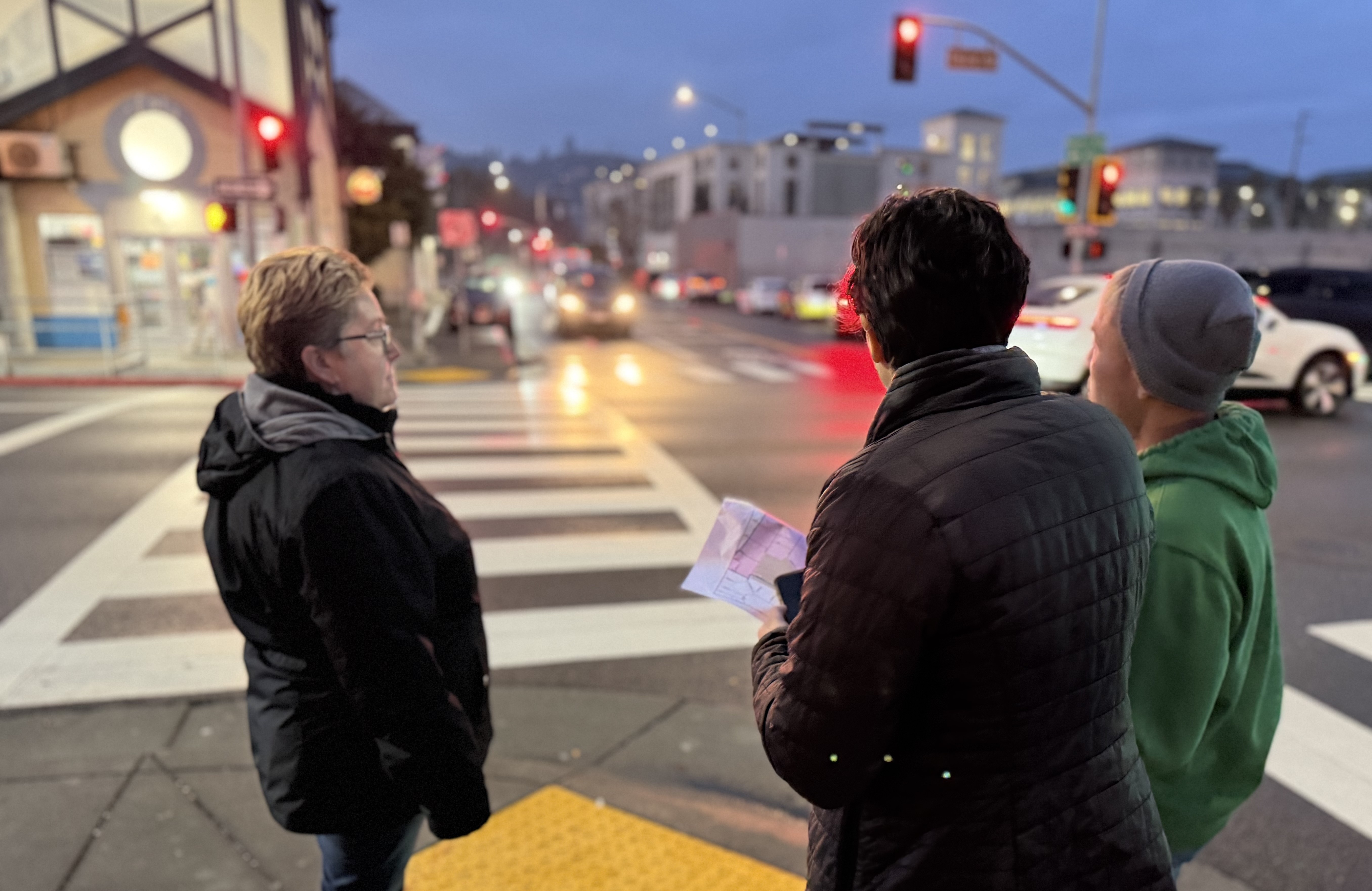 Three people assisting with the Point-in-Time County of homeless individuals look toward downtown San Rafael early in the morning.