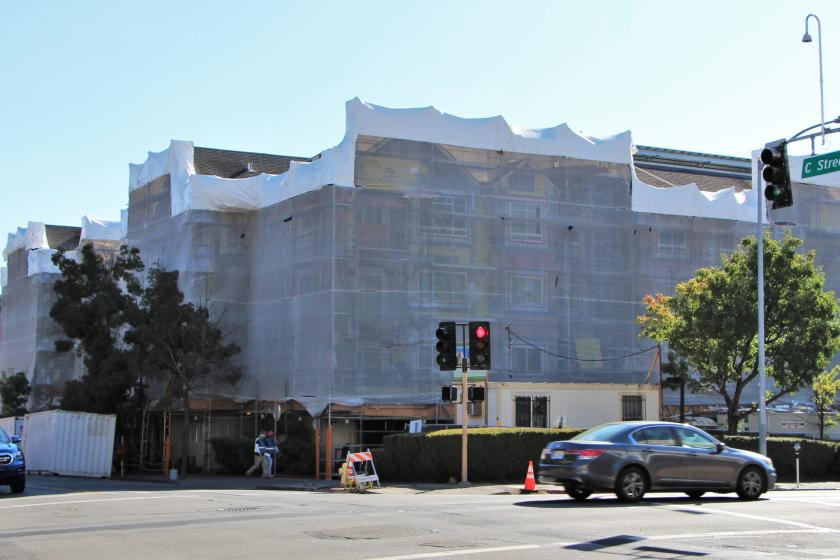 A multiunit housing development under construction, viewed by a street corner.