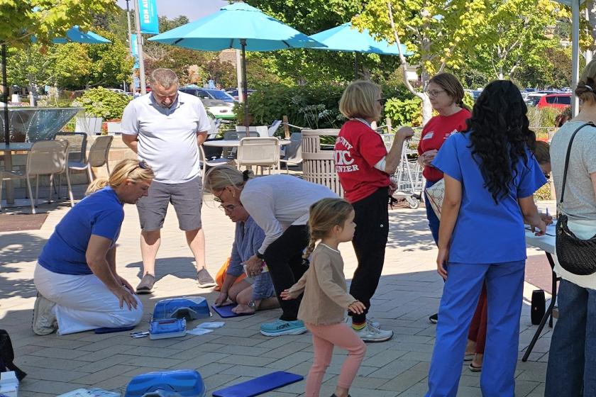 Several people demonstrate CPR with a plastic dummy at last year's Sidewalk CPR event.
