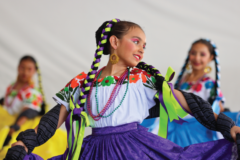 A girl is dancing and twirling her skirt.