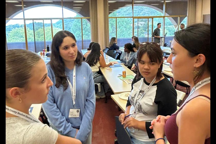Four teenage girls talk about elections with more students in the background at last year's SEAP event.