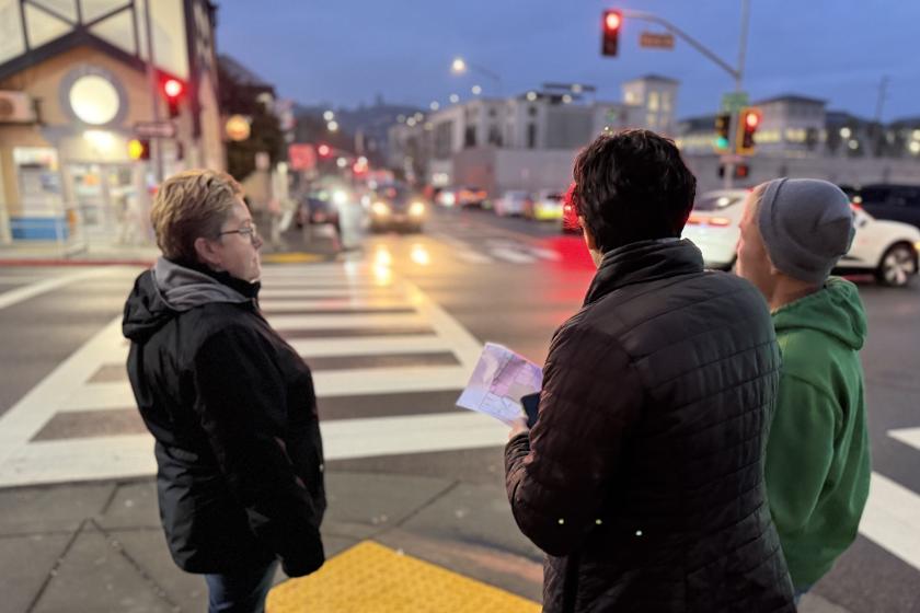 Three people assisting with the Point-in-Time County of homeless individuals look toward downtown San Rafael early in the morning.