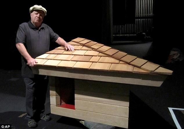 Jim Berger, the owner of the doghouse designed by Frank Lloyd Wright standing next to the reconstructed doghouse.