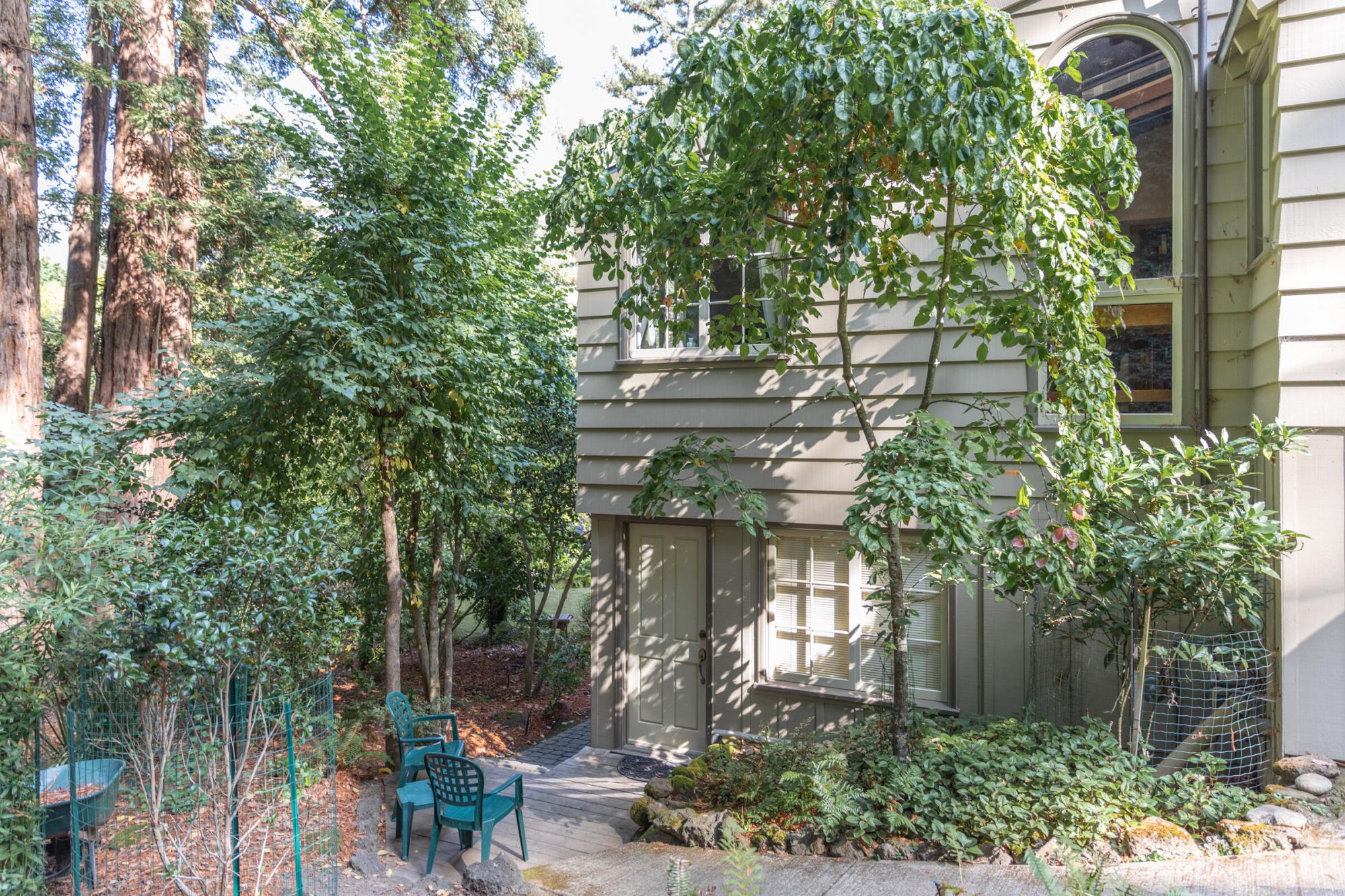 Converted garage to ADU in Corte Madera with lush greenery surrounding entrance.