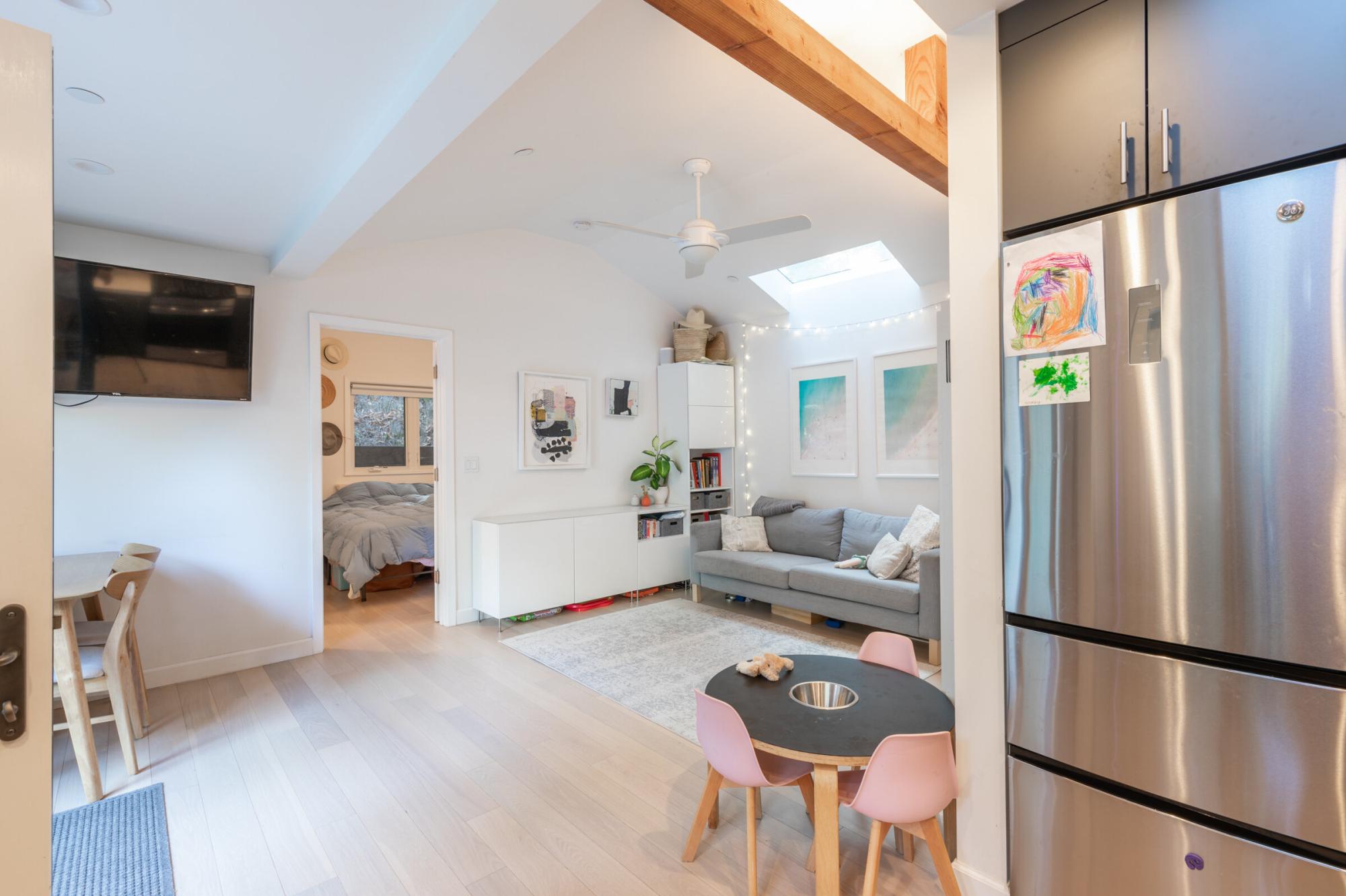 Interior view of living room, part of bedroom and part of kitchen of an ADU that was created through the conversion of an existing structure in San Anselmo.
